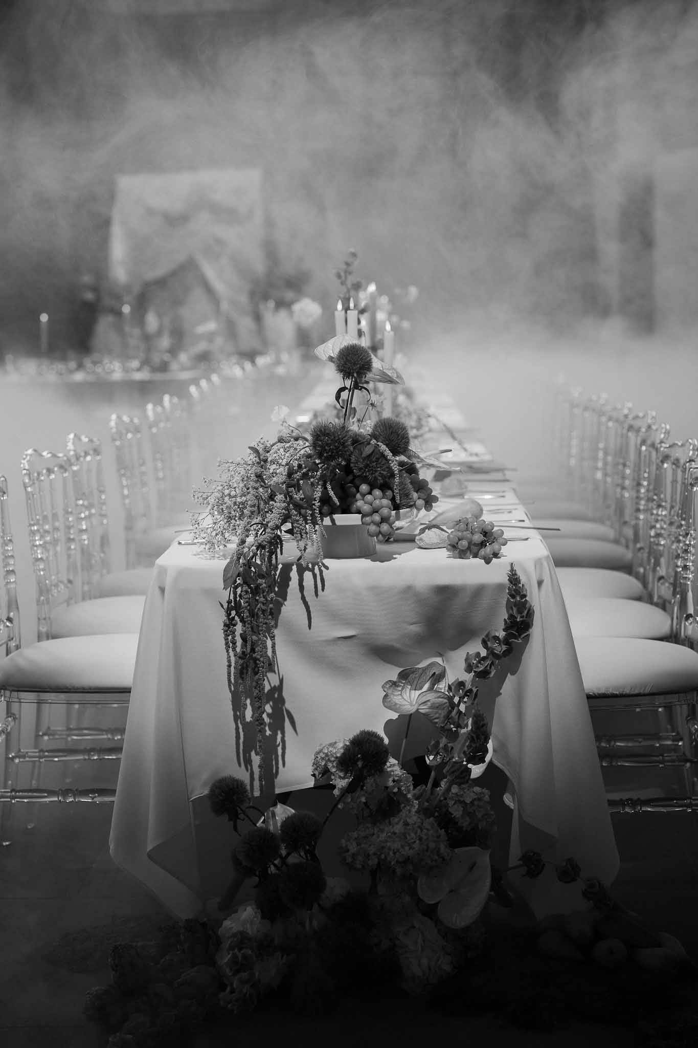 Black and white photo of wedding reception table setting with white roses