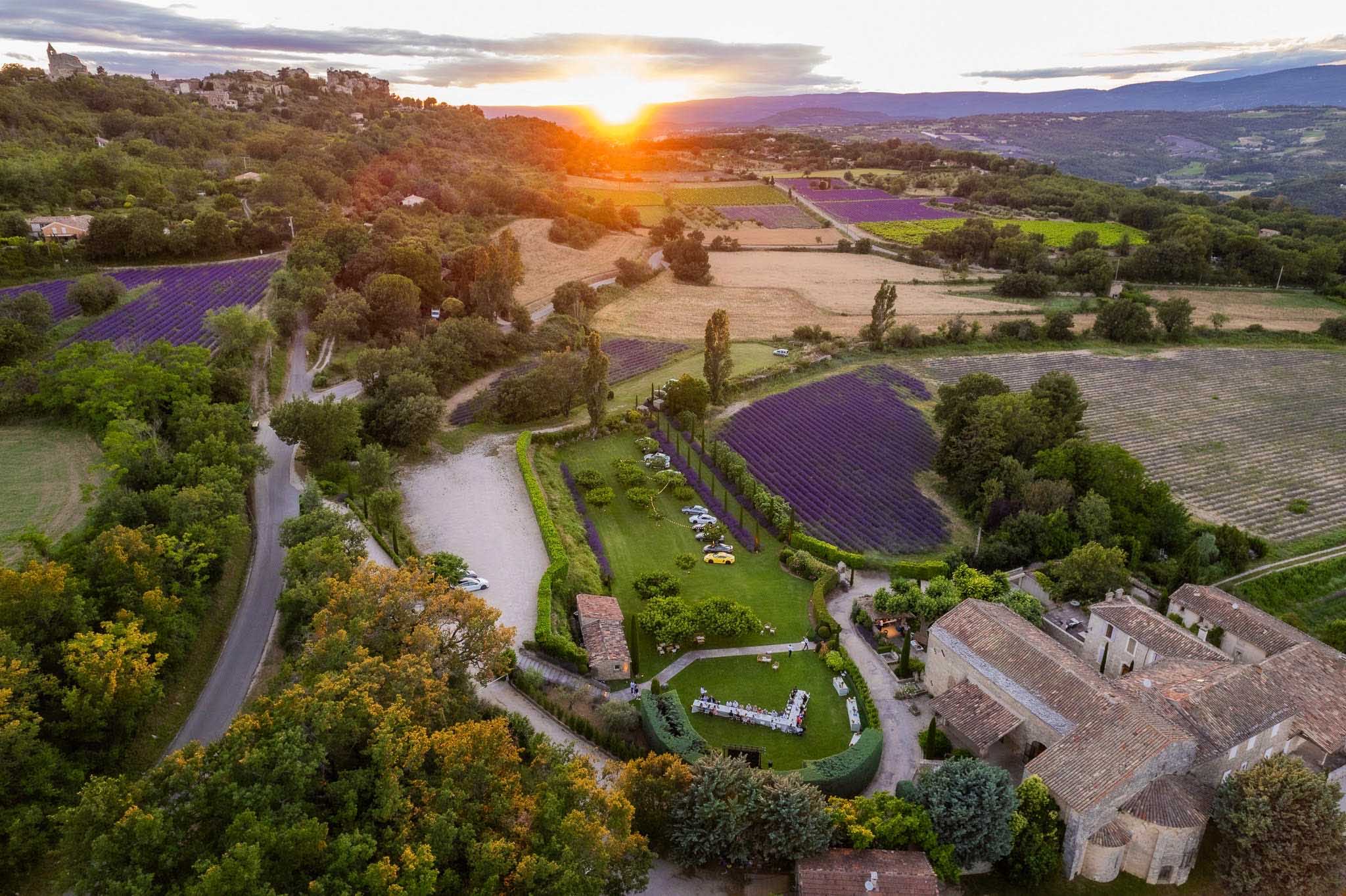 Aerial sunset view of Provencal property with wedding dinner in garden surrounded by lavender fields and vineyards
