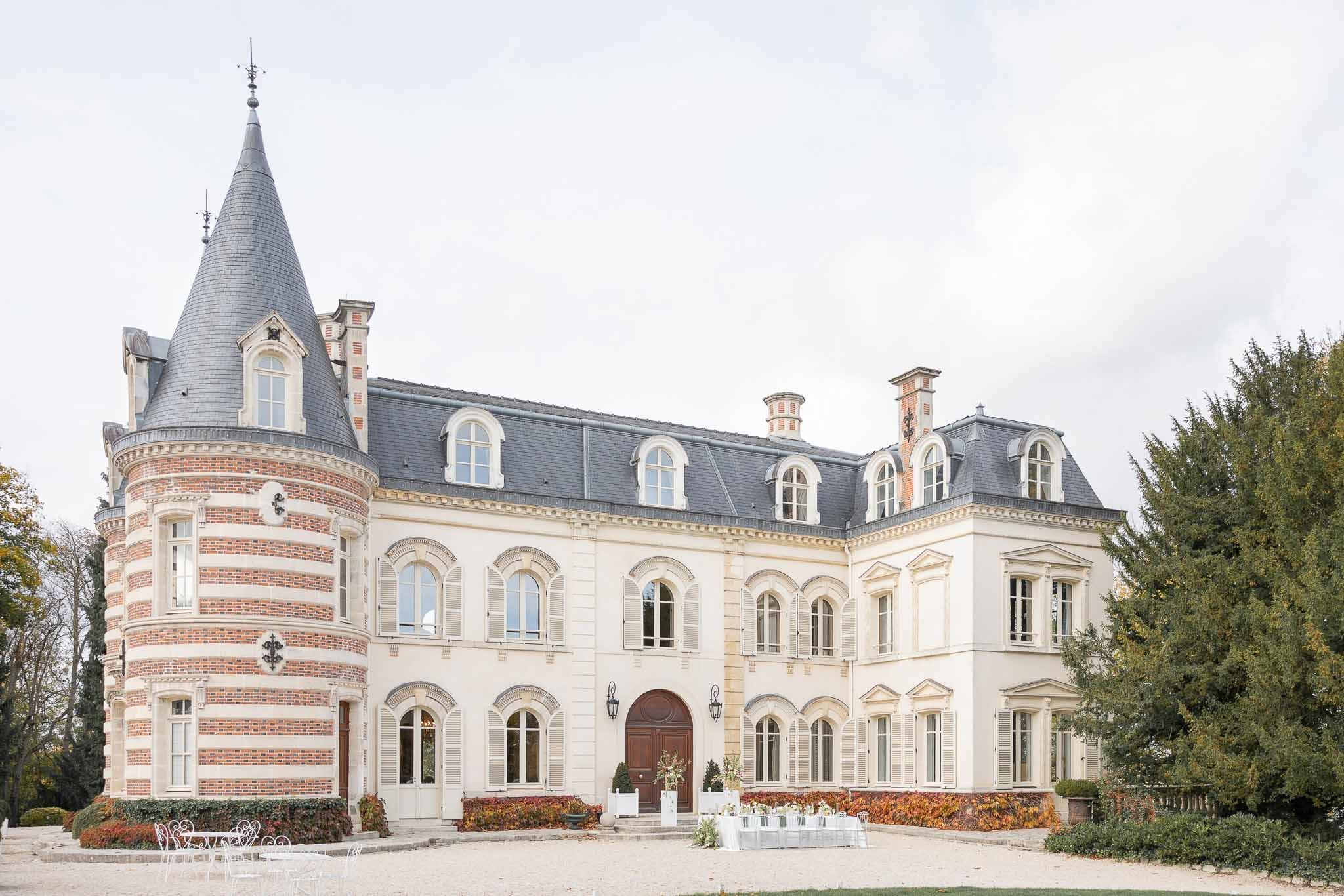 Side view of Château Comtesse Lafond with turret and autumn trees in Épernay
