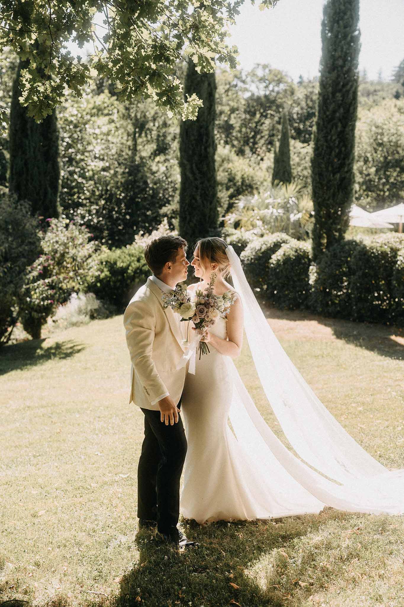 Couple nose to nose in cypress garden with bride holding mauve and dusty lilac rose bouquet