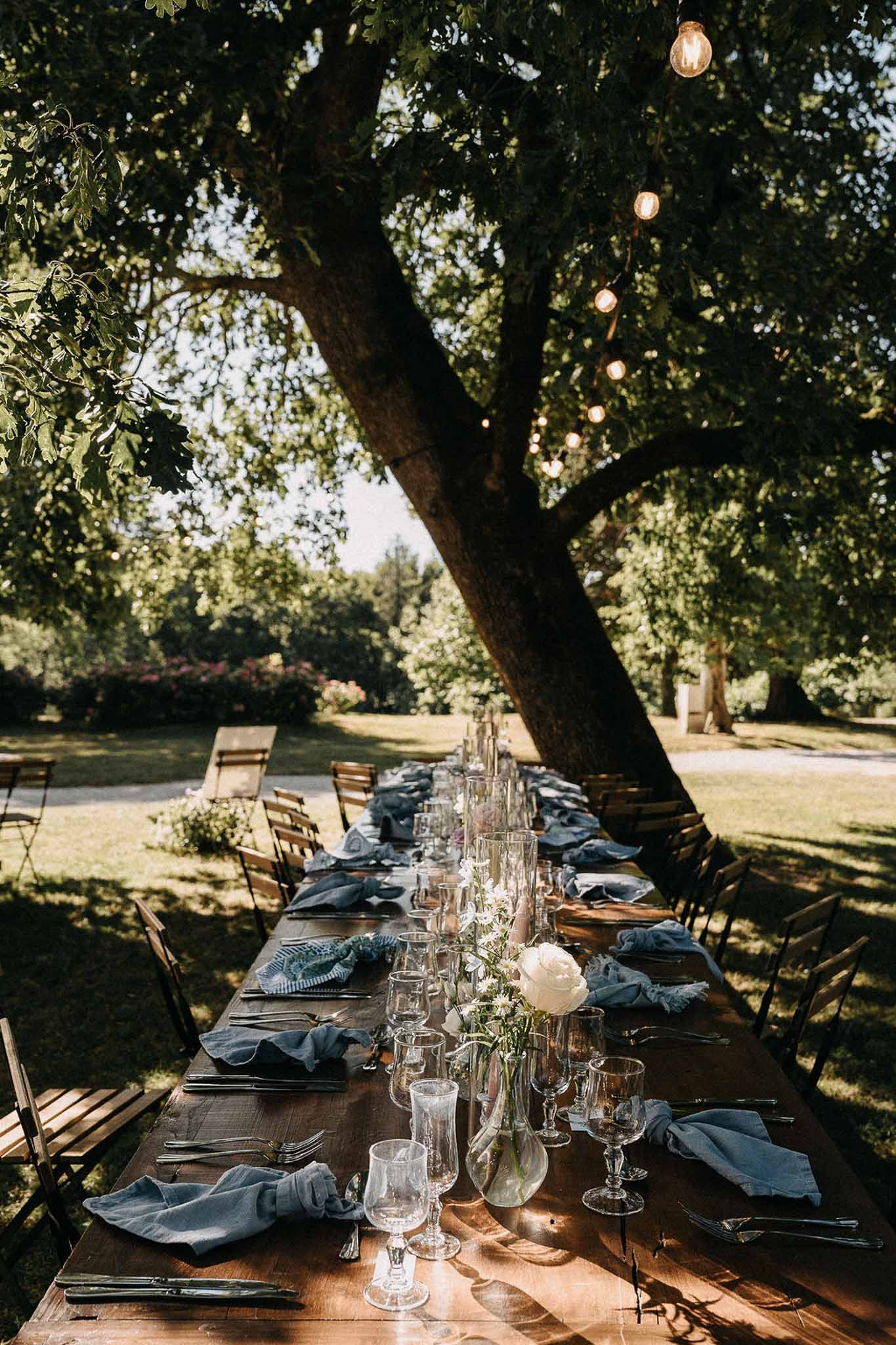 Wedding reception table setting in a garden with white roses