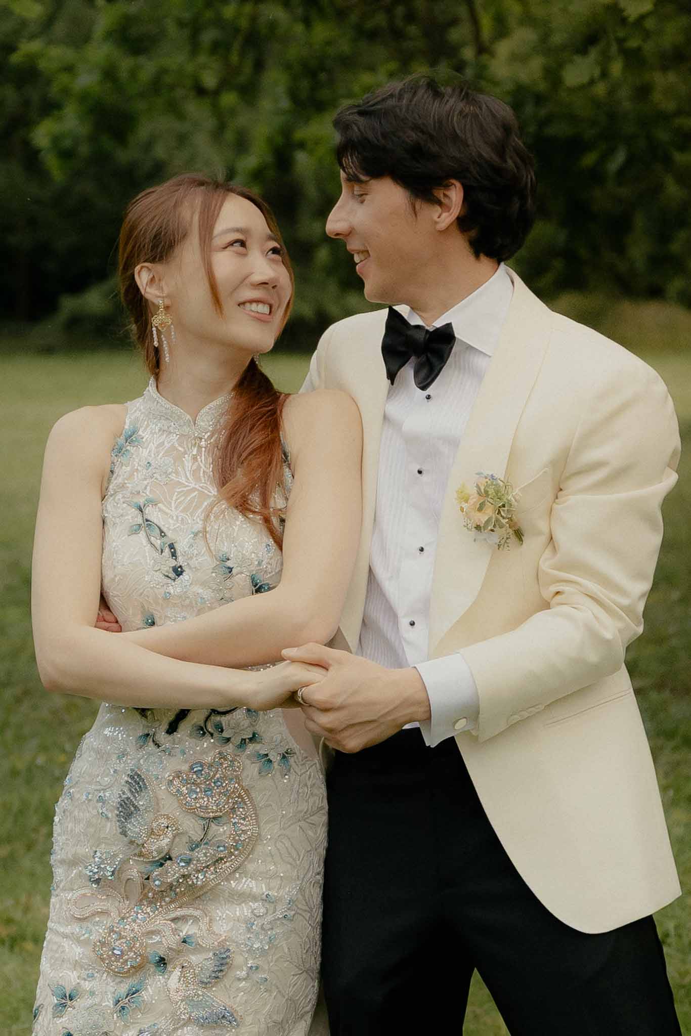 Bride and groom walking hand in hand in a garden