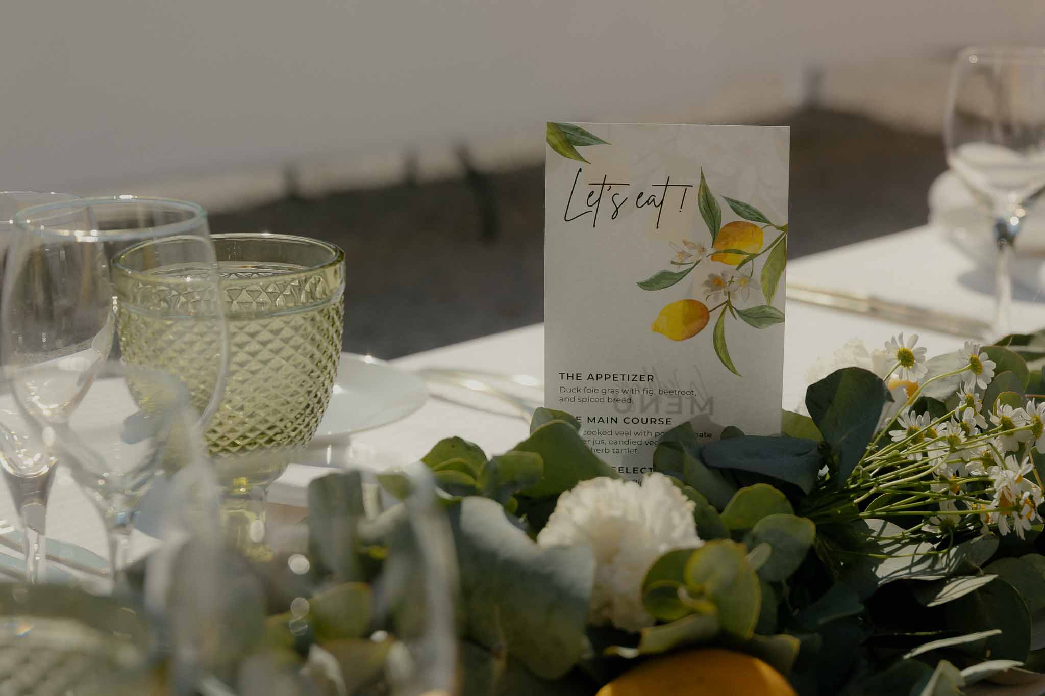 Lets Eat menu card with lemon illustration beside eucalyptus and lemon garland table runner