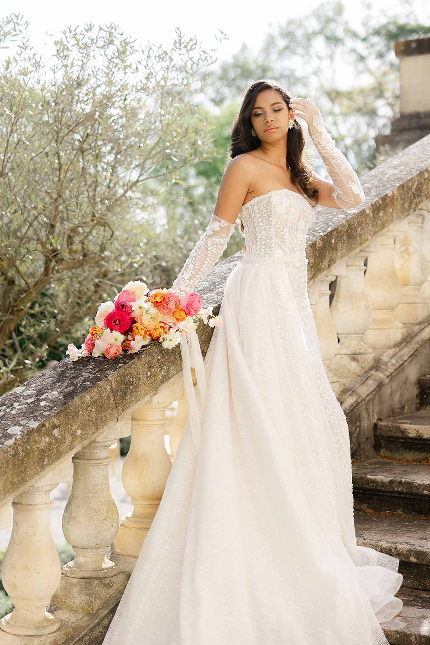 Bride holding pink blush bouquet in lace gown with gloves at Château Martinay
