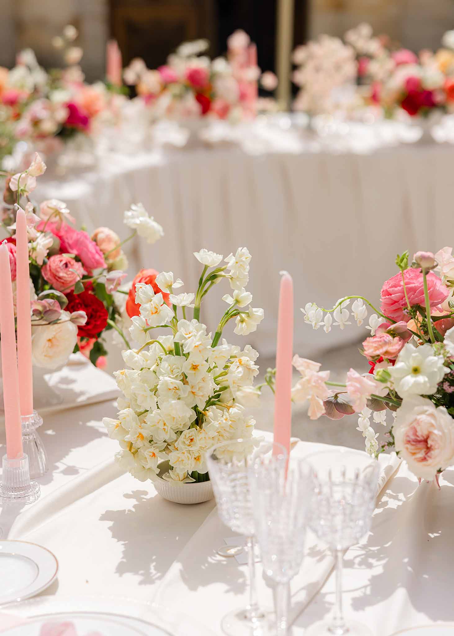Pink and white flower centrepiece with candles at Château Martinay reception