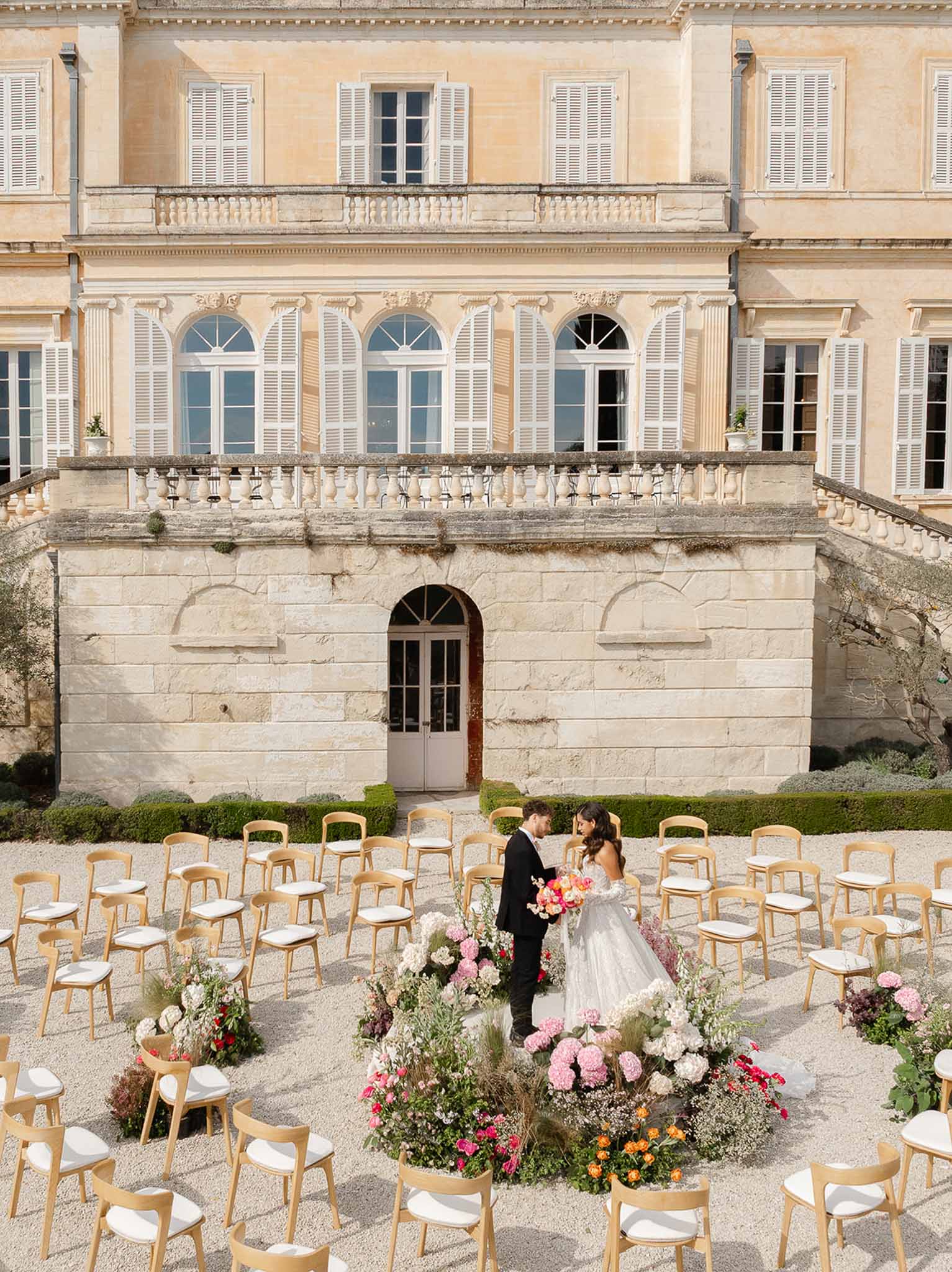 Couple at floral arch altar during ceremony at Château Martinay, Provence