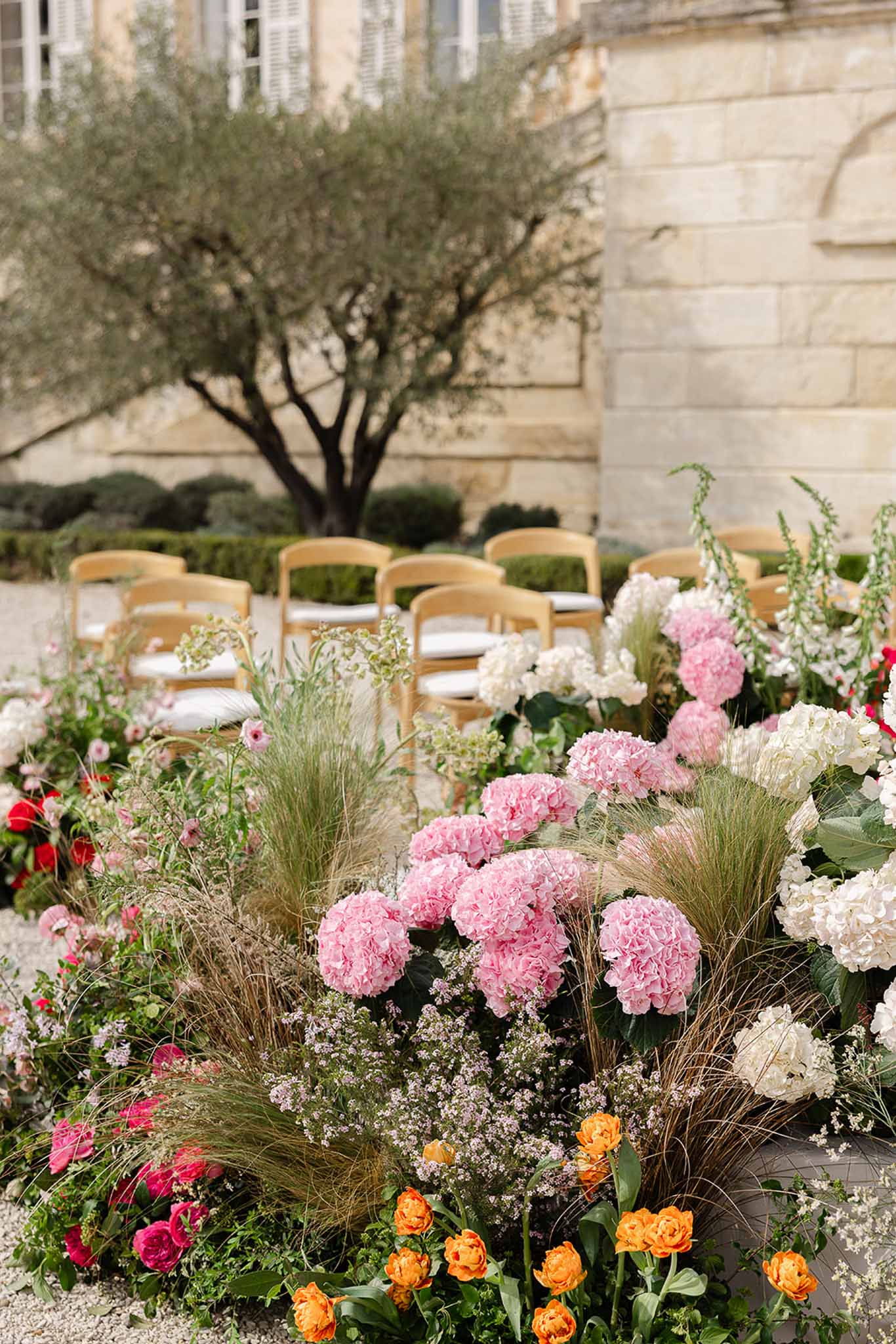 Deep pink and blush floral arch at ceremony altar, Château Martinay, Provence