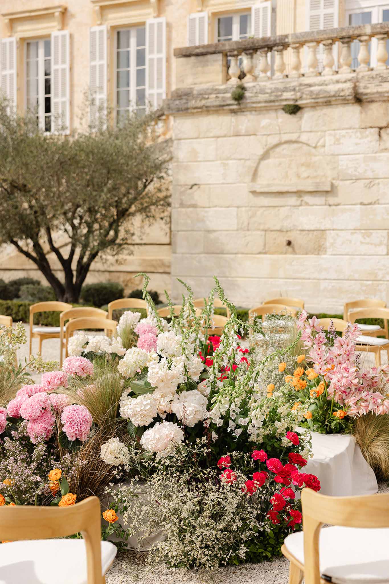 Pink and blush floral arch at ceremony altar, Château Martinay