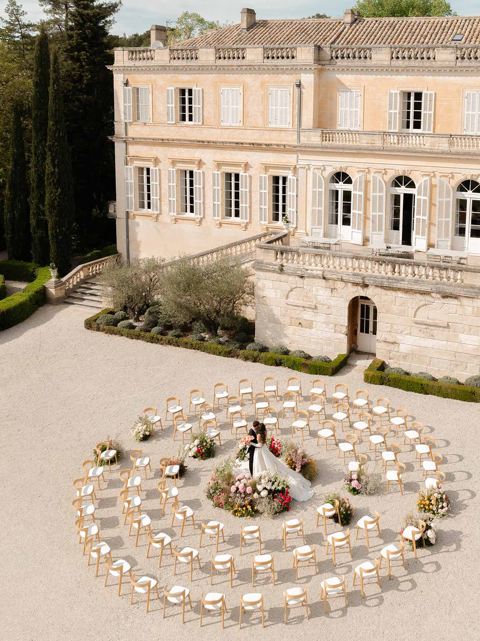 Couple kissing at the altar in the centre of circular ceremony seating at Château Martinay