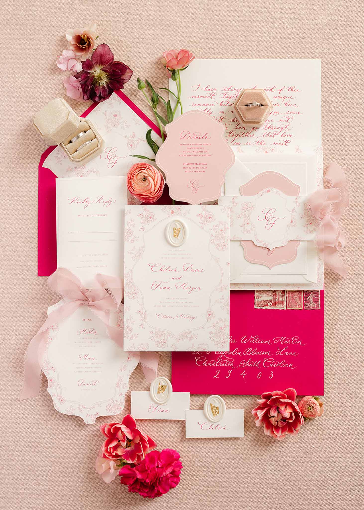 Flat lay of pink invitation suite with flowers and wedding rings, Château Martinay
