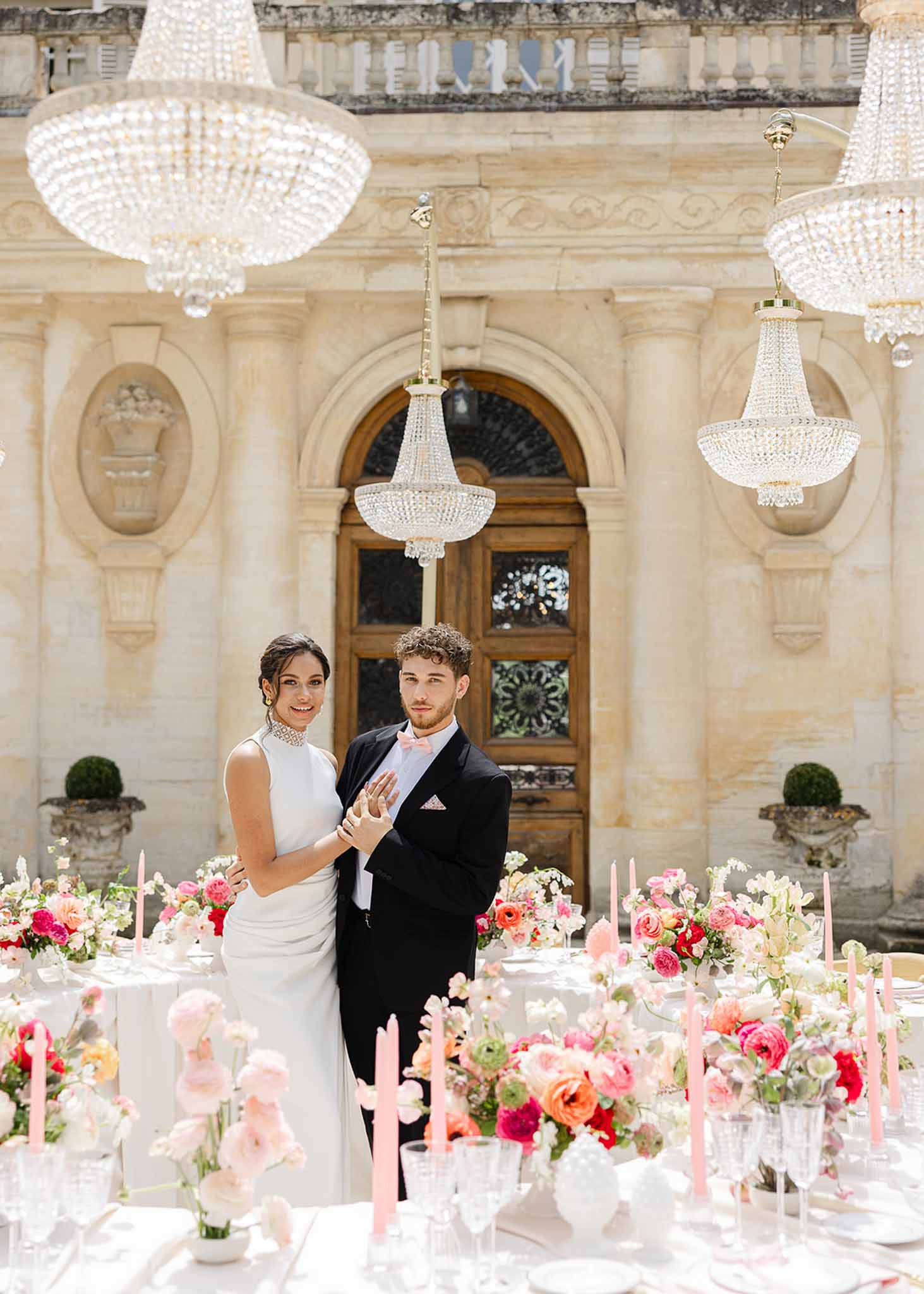 Couple under crystal chandeliers in reception area at Château Martinay