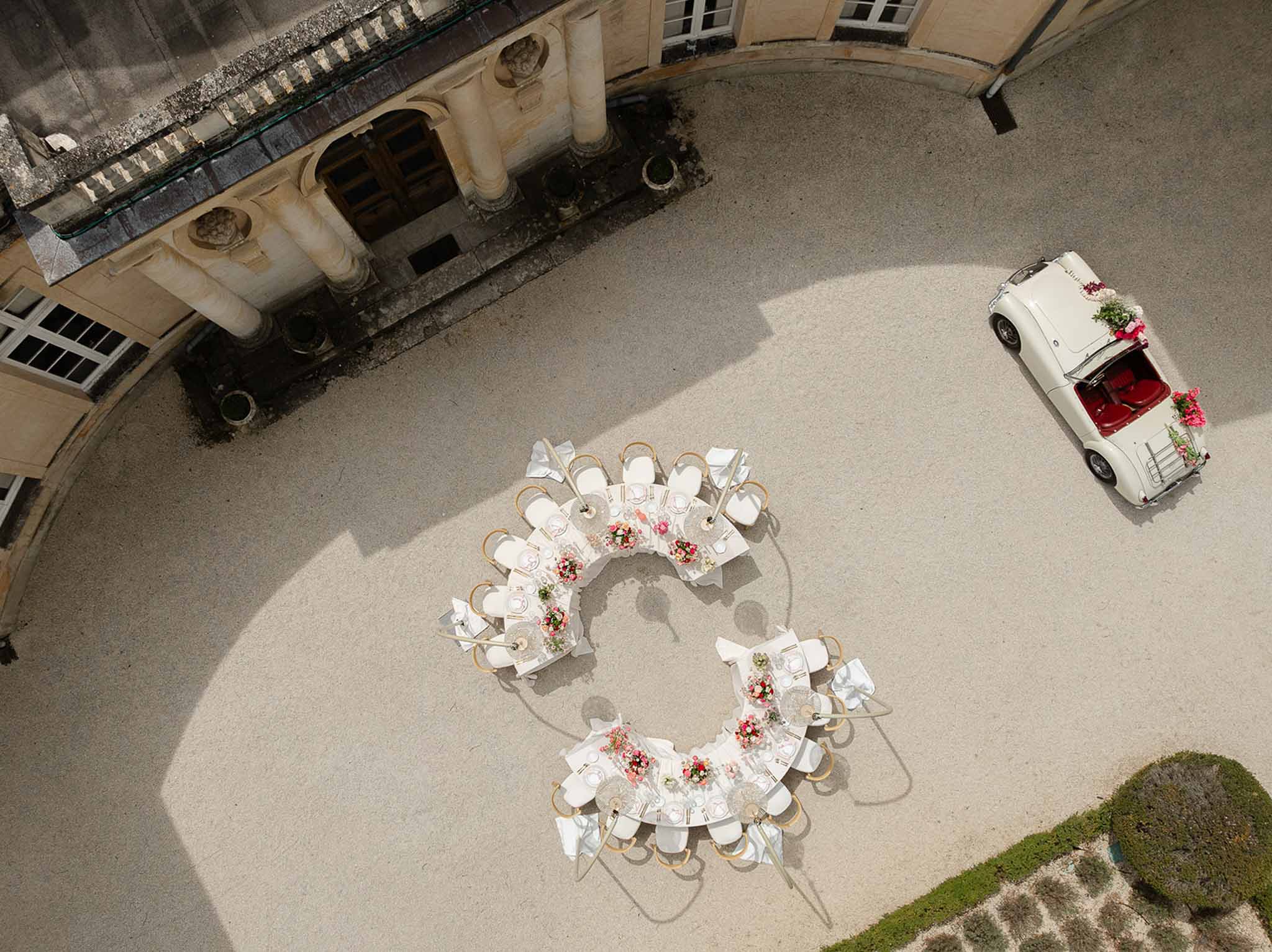 Aerial view of round reception tablescape with crystal chandeliers at Château Martinay