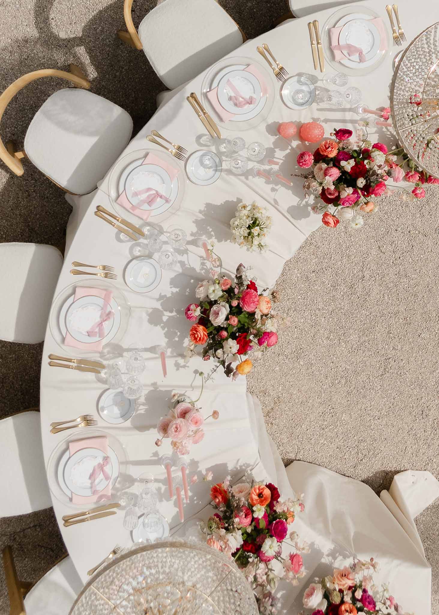 Pink floral centrepiece on gold tableware at Château Martinay reception