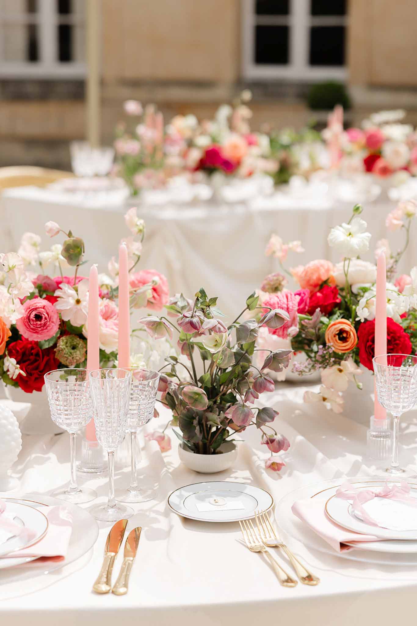 Gold tableware with pink flower and candle centrepiece at Château Martinay
