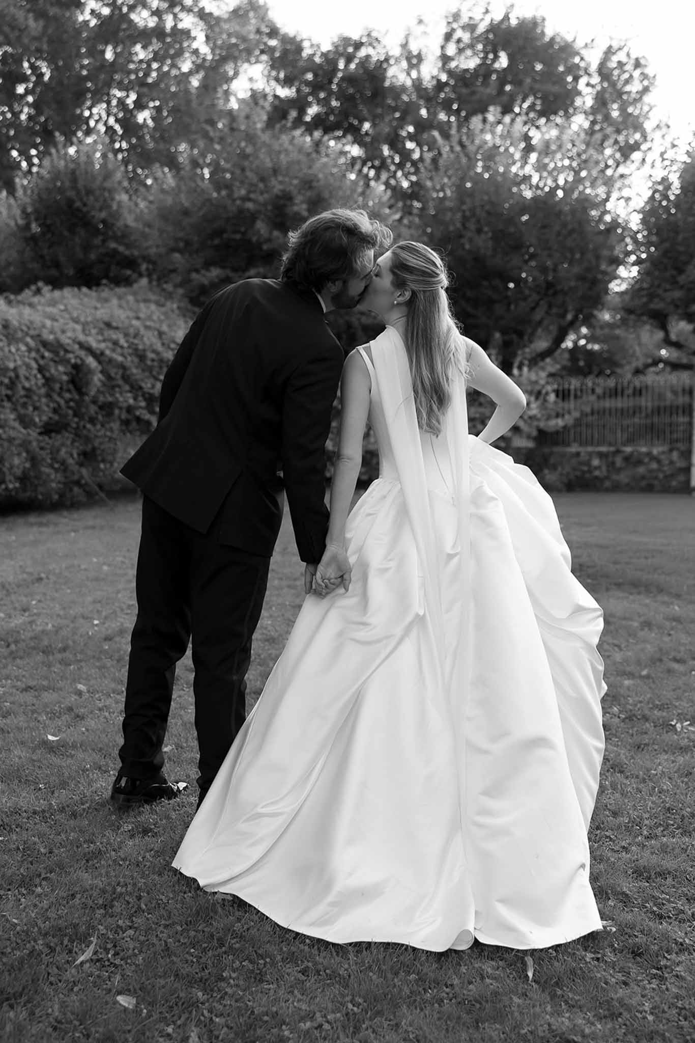 Black and white photo of bride and groom kissing