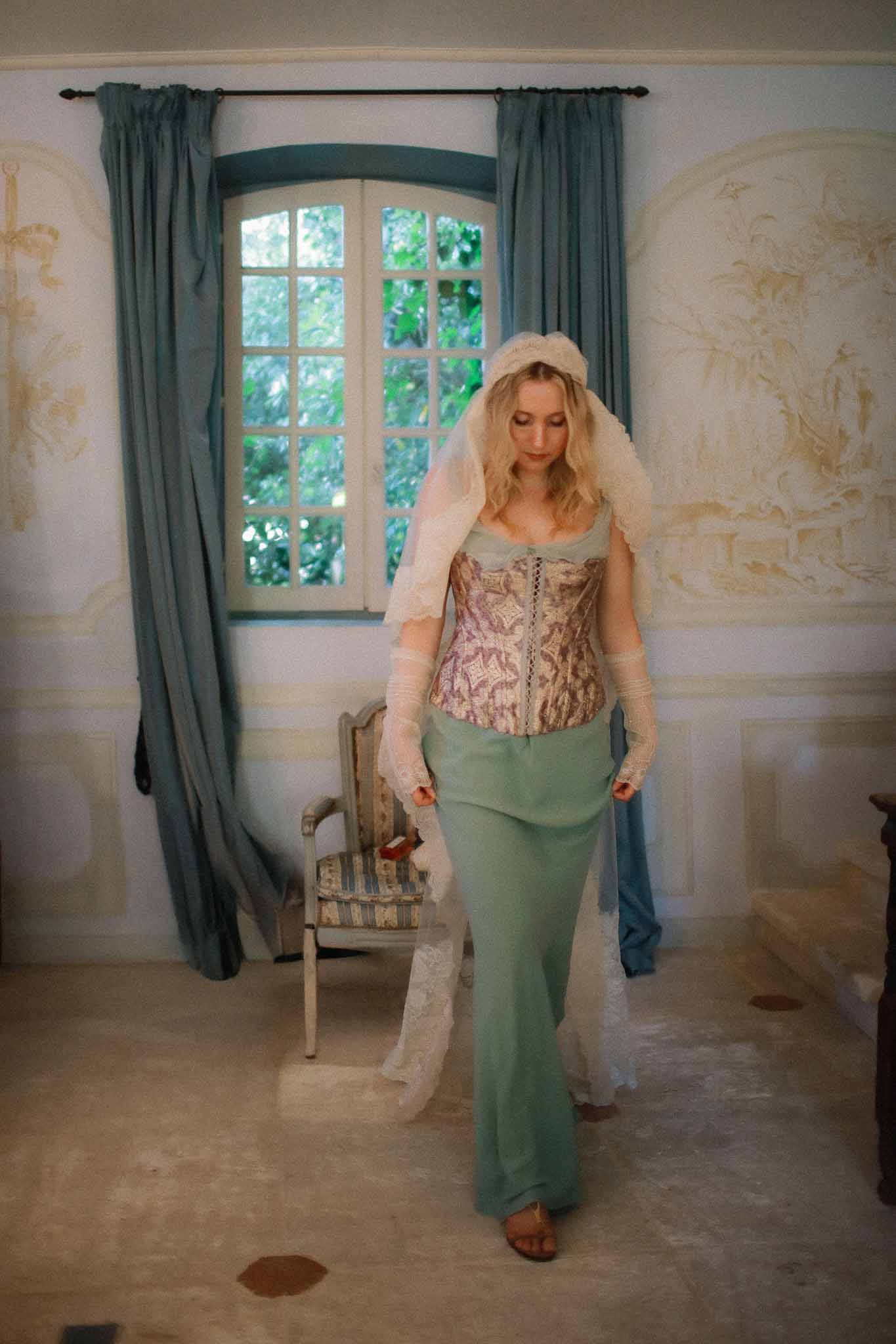 Bride wearing corset dress and long lace veil at Chateau St Victor Lacoste