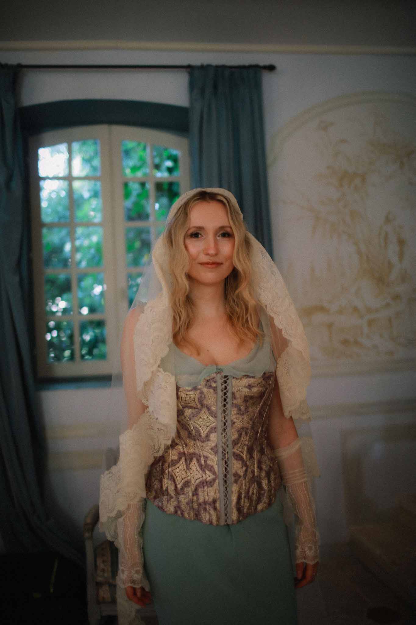 Detail of bride's corset dress with vintage lace veil at Chateau St Victor Lacoste