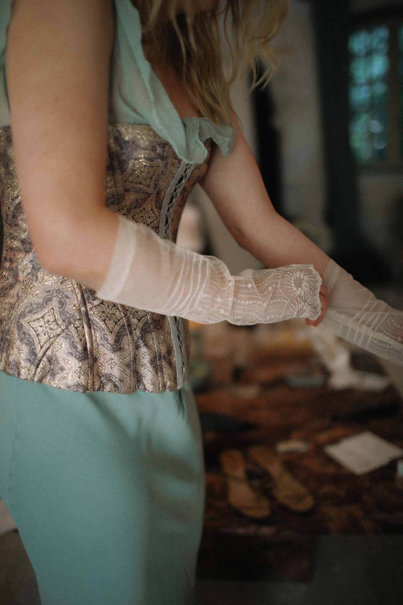 Bride wearing corset wedding dress with vintage gloves at Chateau St Victor Lacoste