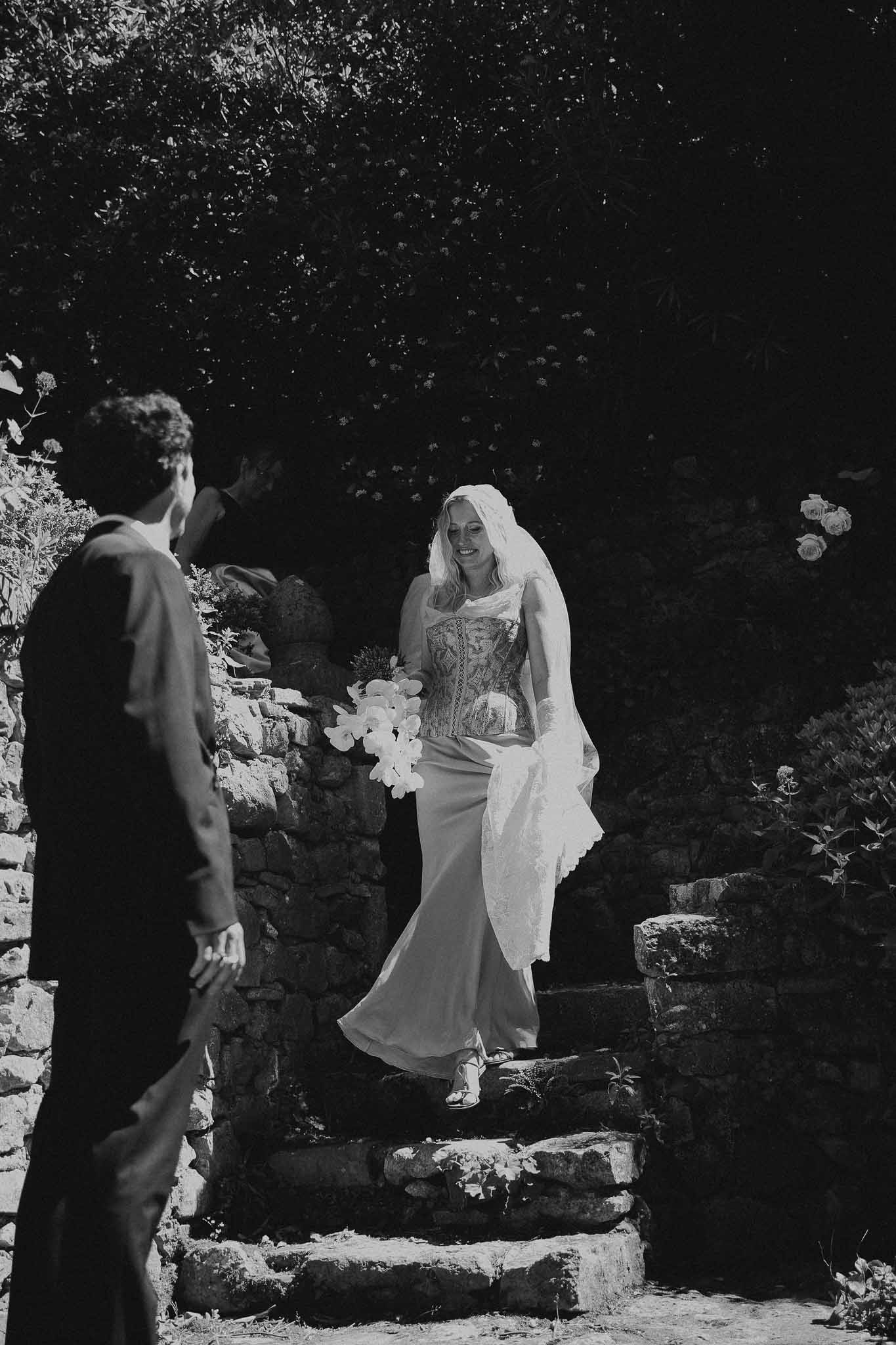 Bride walking down chateau stairs in first look moment at Chateau St Victor Lacoste