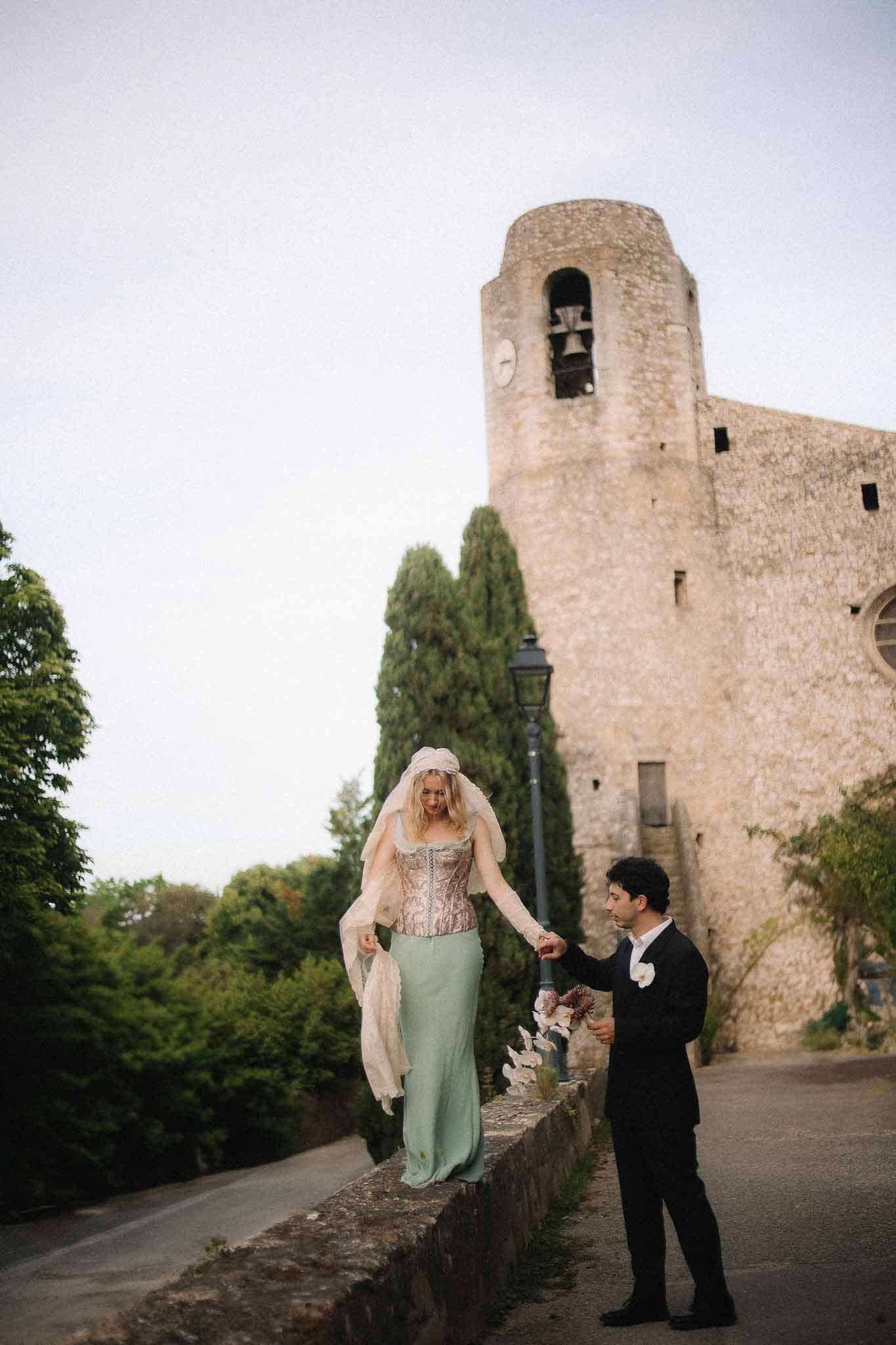 Bride holding groom's arm while walking at Chateau St Victor Lacoste