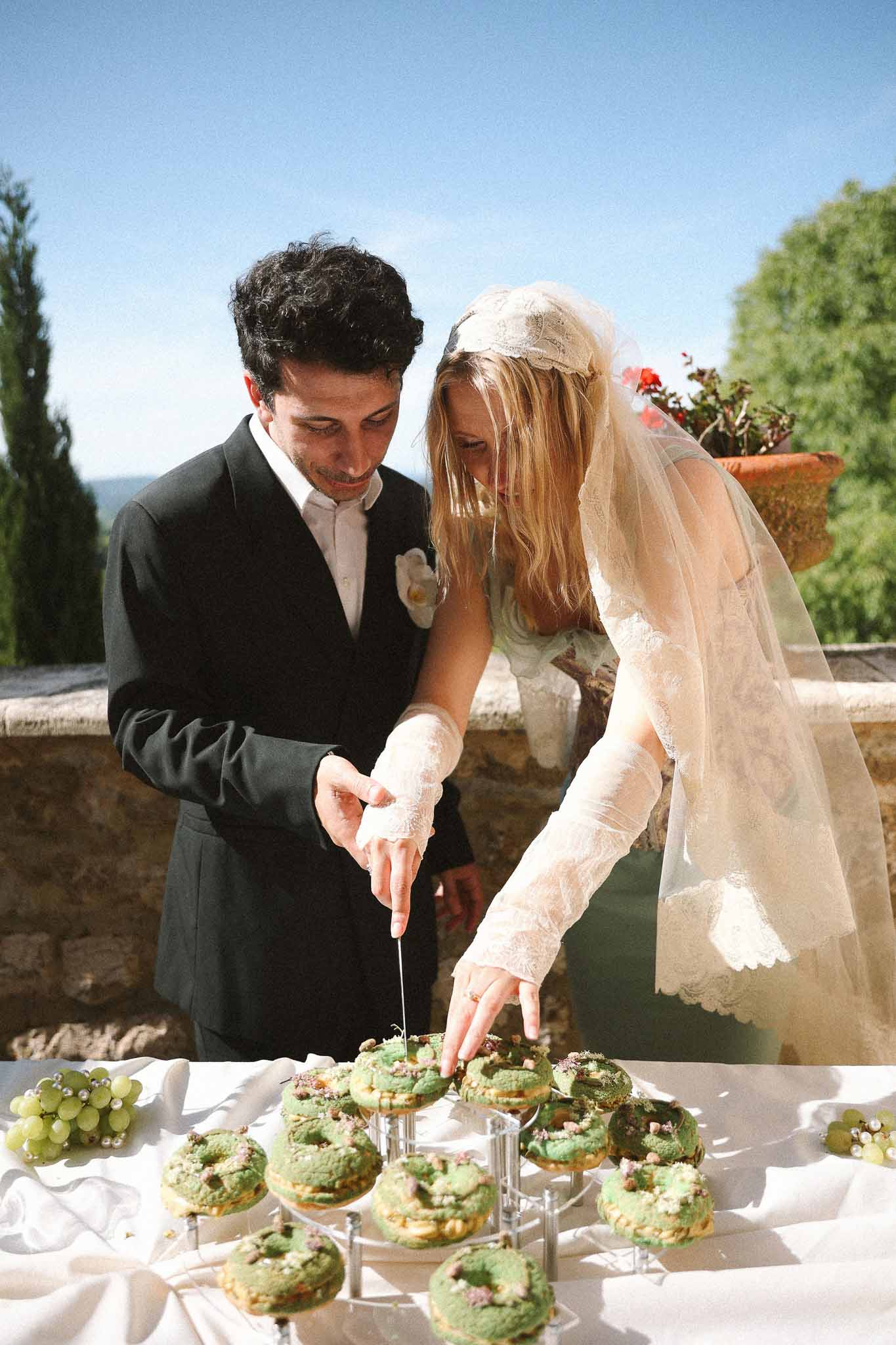 Couple slicing wedding cake at reception at Chateau St Victor Lacoste