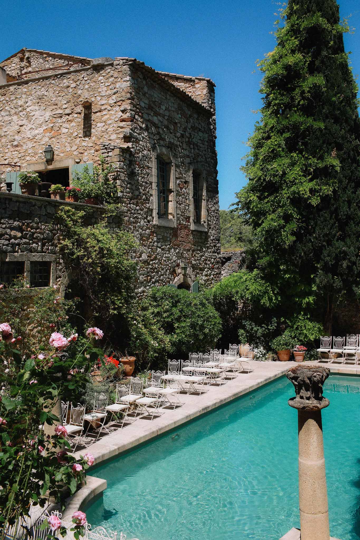 Ceremony seating arrangement by pool and garden at Chateau St Victor Lacoste