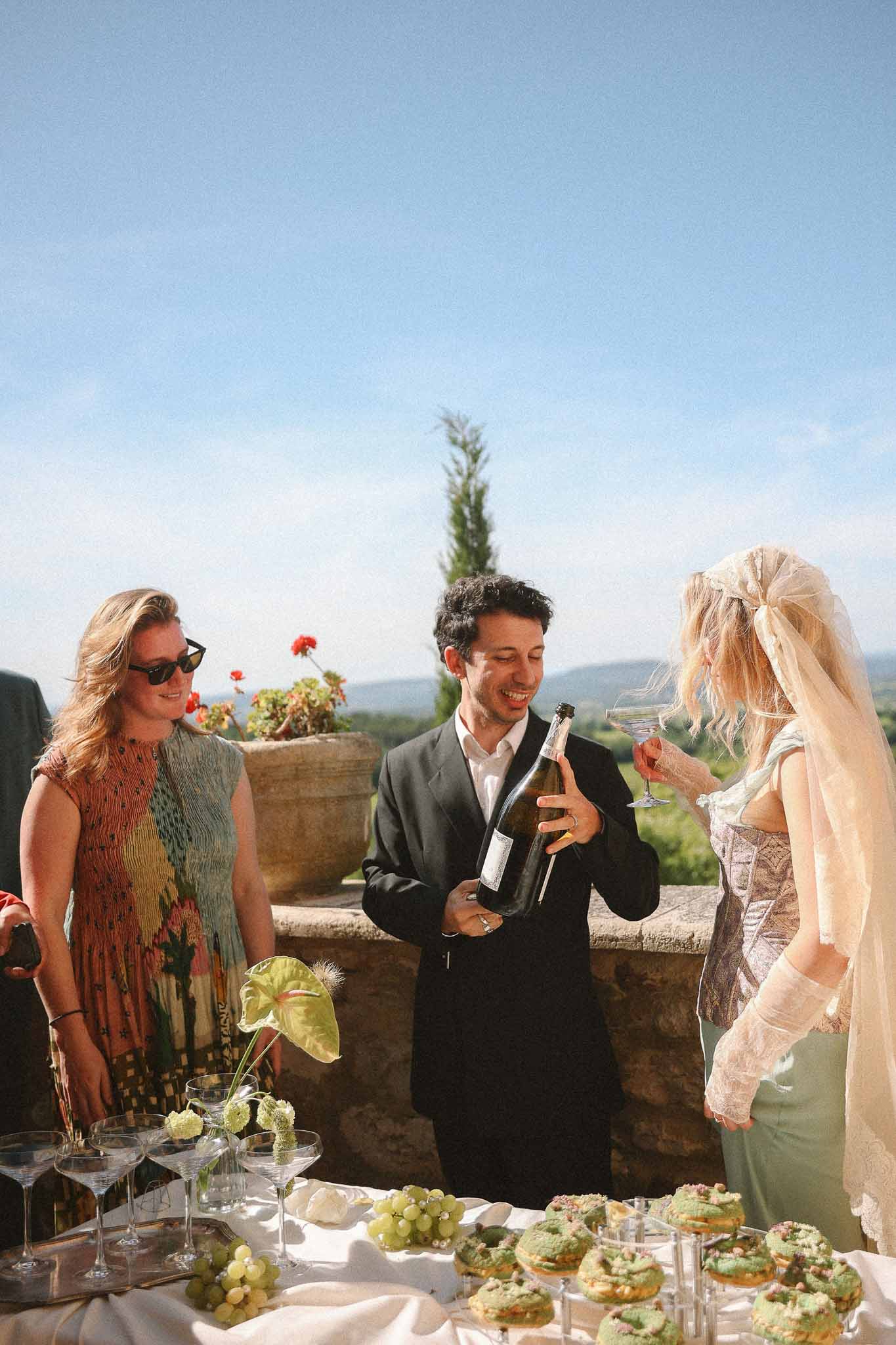 Groom holding champagne bottle at Chateau St Victor Lacoste reception