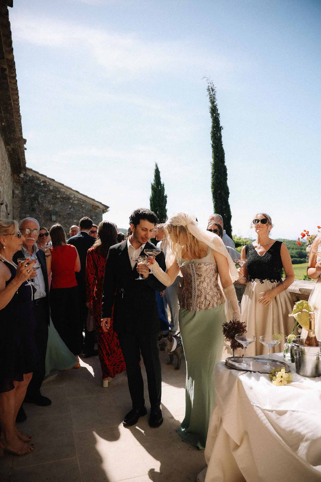 Couple holding champagne glasses during cocktail hour at Chateau St Victor Lacoste