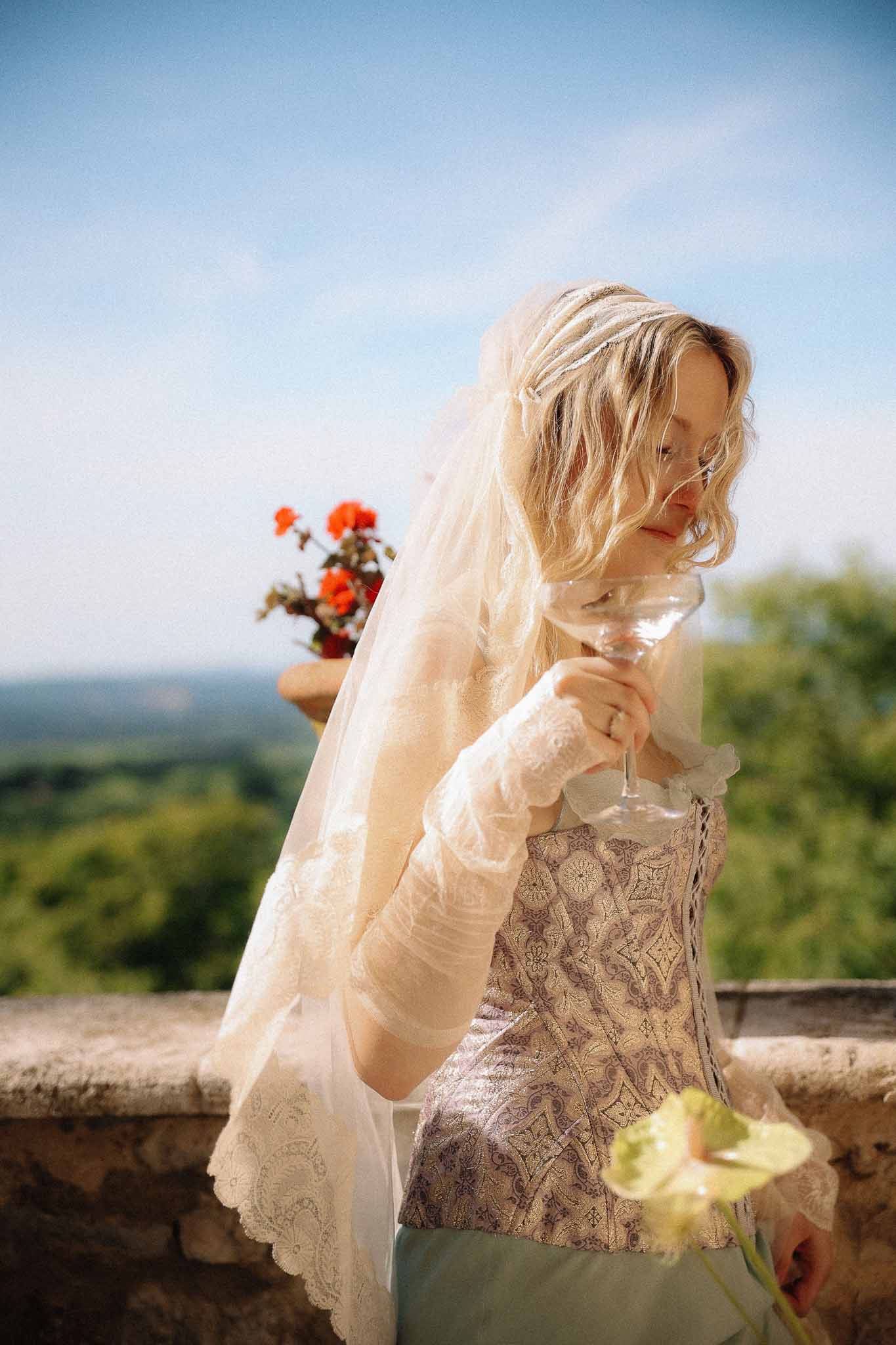 Bride holding champagne glass during golden hour at Chateau St Victor Lacoste