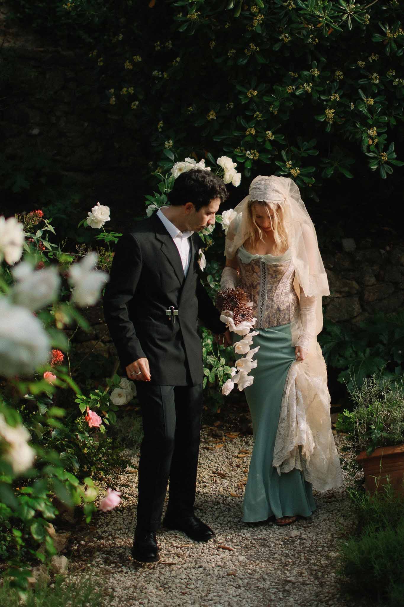 Couple walking together through gardens in golden light at Chateau St Victor Lacoste