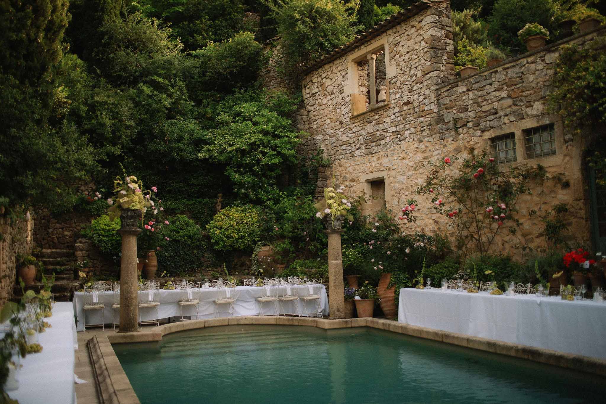 Wide view of poolside reception with garden surroundings at Chateau St Victor Lacoste