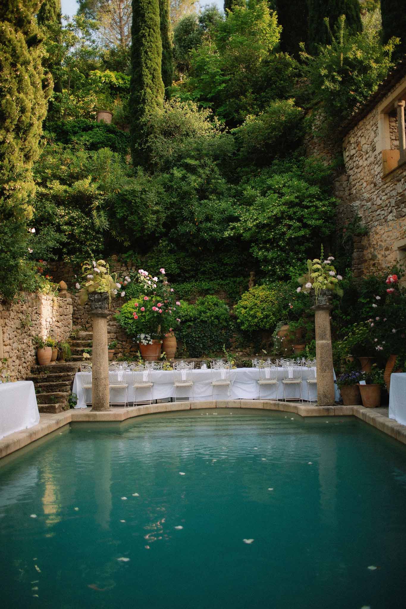 Reception tables between pool and garden at Chateau St Victor Lacoste