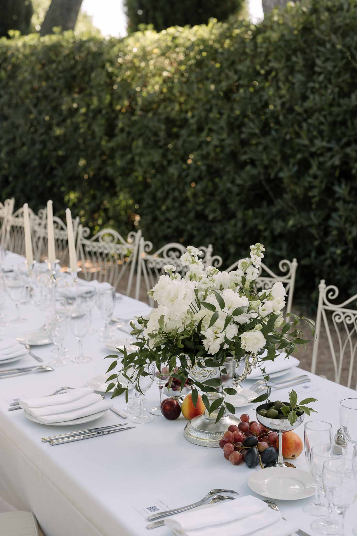 Wedding reception table setting in a garden with white roses