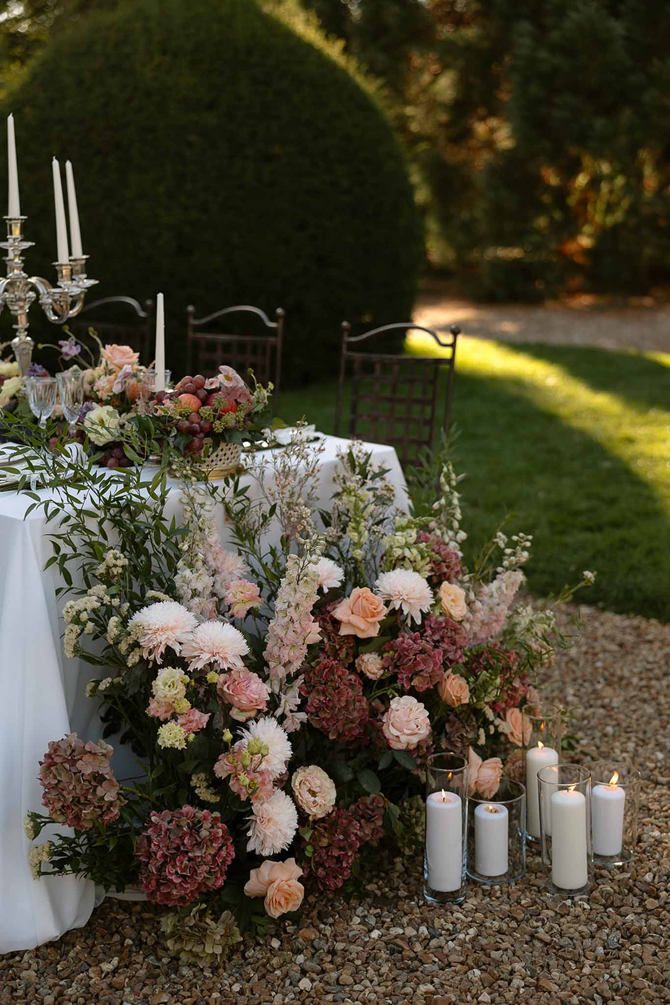 Cascading blush rose dahlia and dusty mauve hydrangea arrangement with silver candelabra and pillar candles