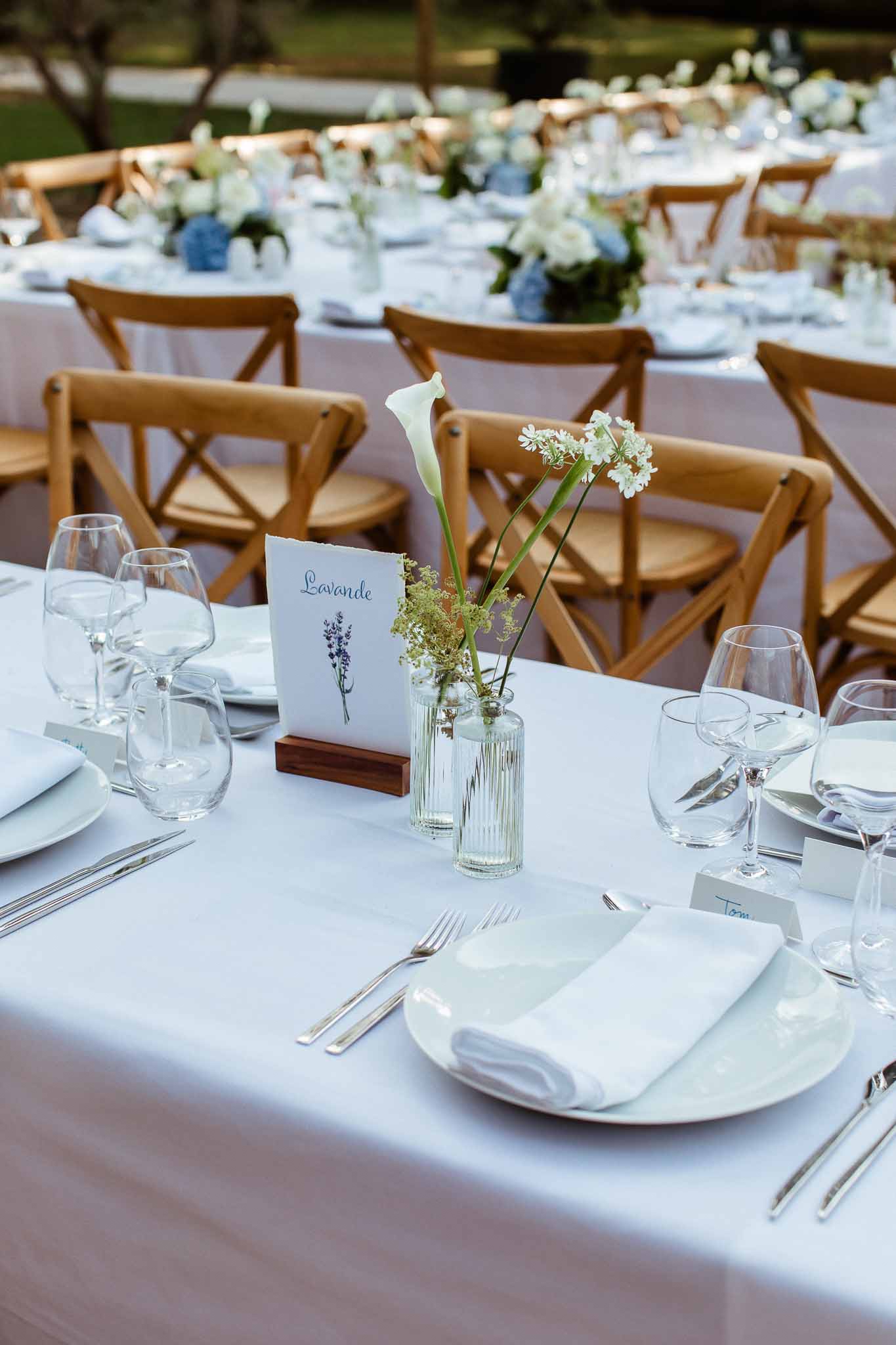 Reception table detail with calla lily bud vases, Lavande table card, and blue hydrangea arrangements