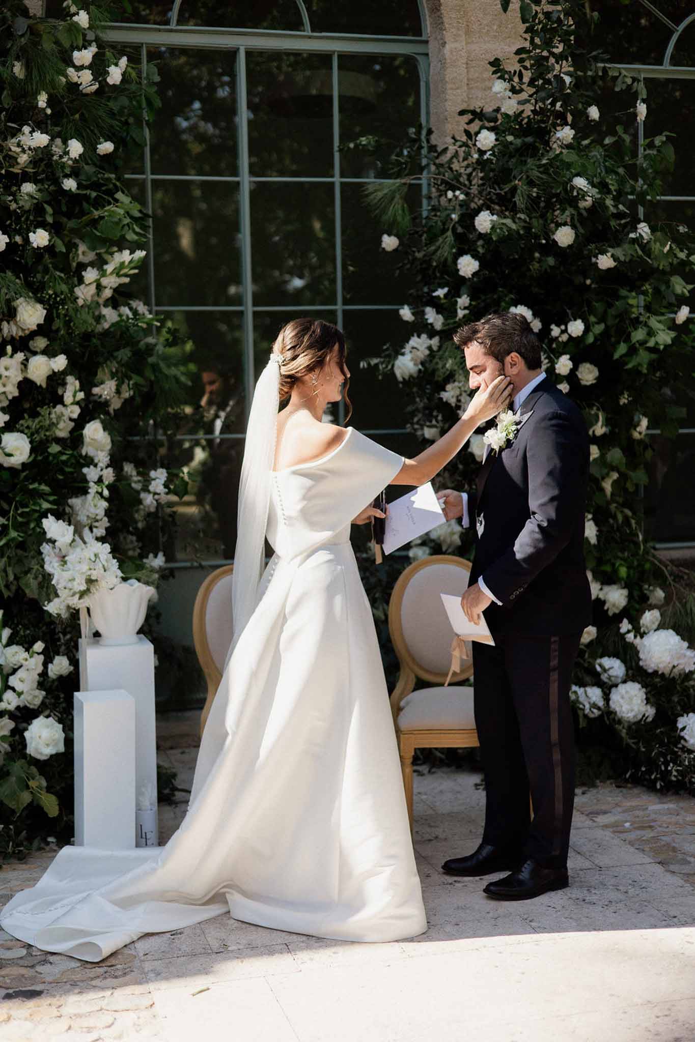 Couple exchanging vows in a garden with white roses