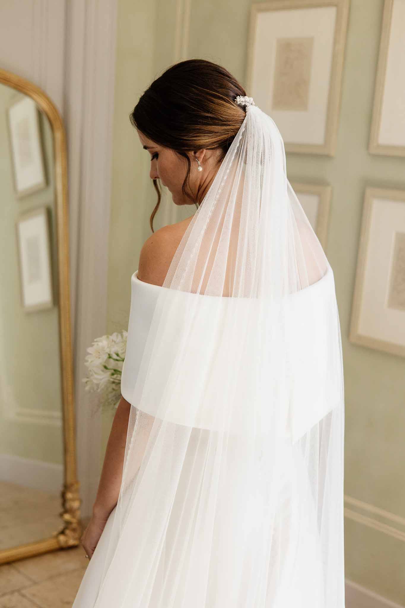 Rear bridal portrait with cathedral tulle veil and floral comb in sage green paneled room