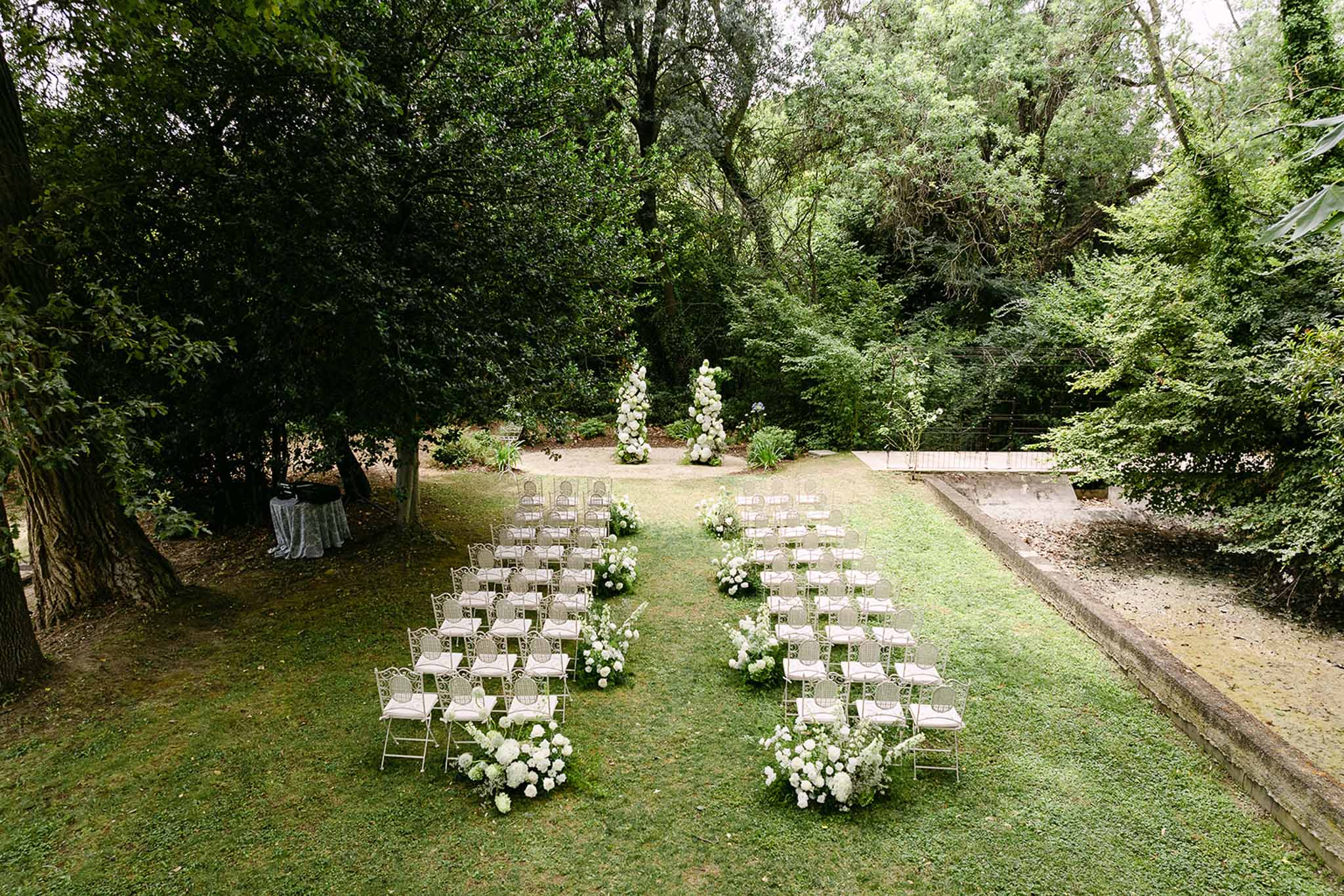 Wedding ceremony setup in a garden with hydrangeas