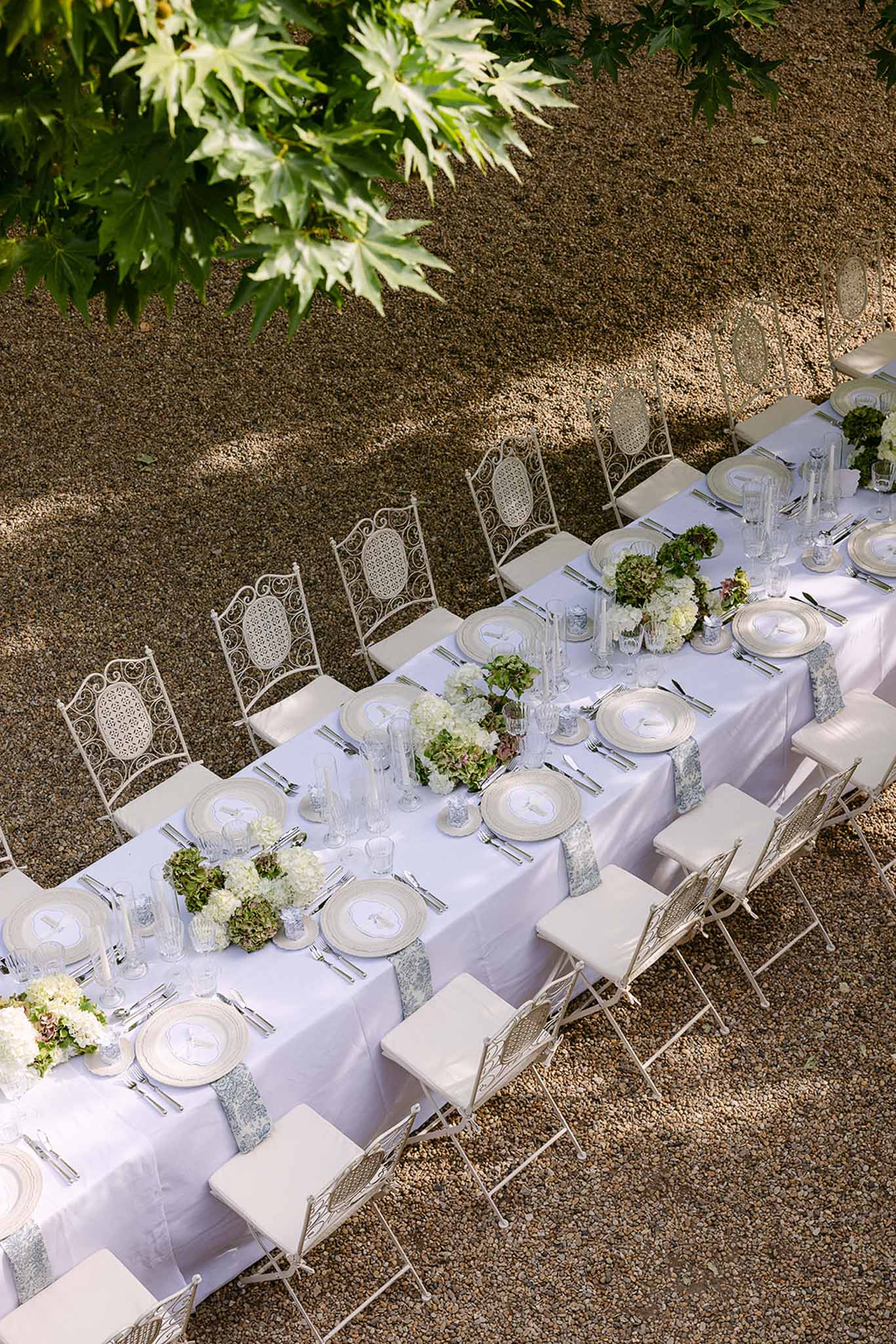Wedding reception table setting in a garden with hydrangeas