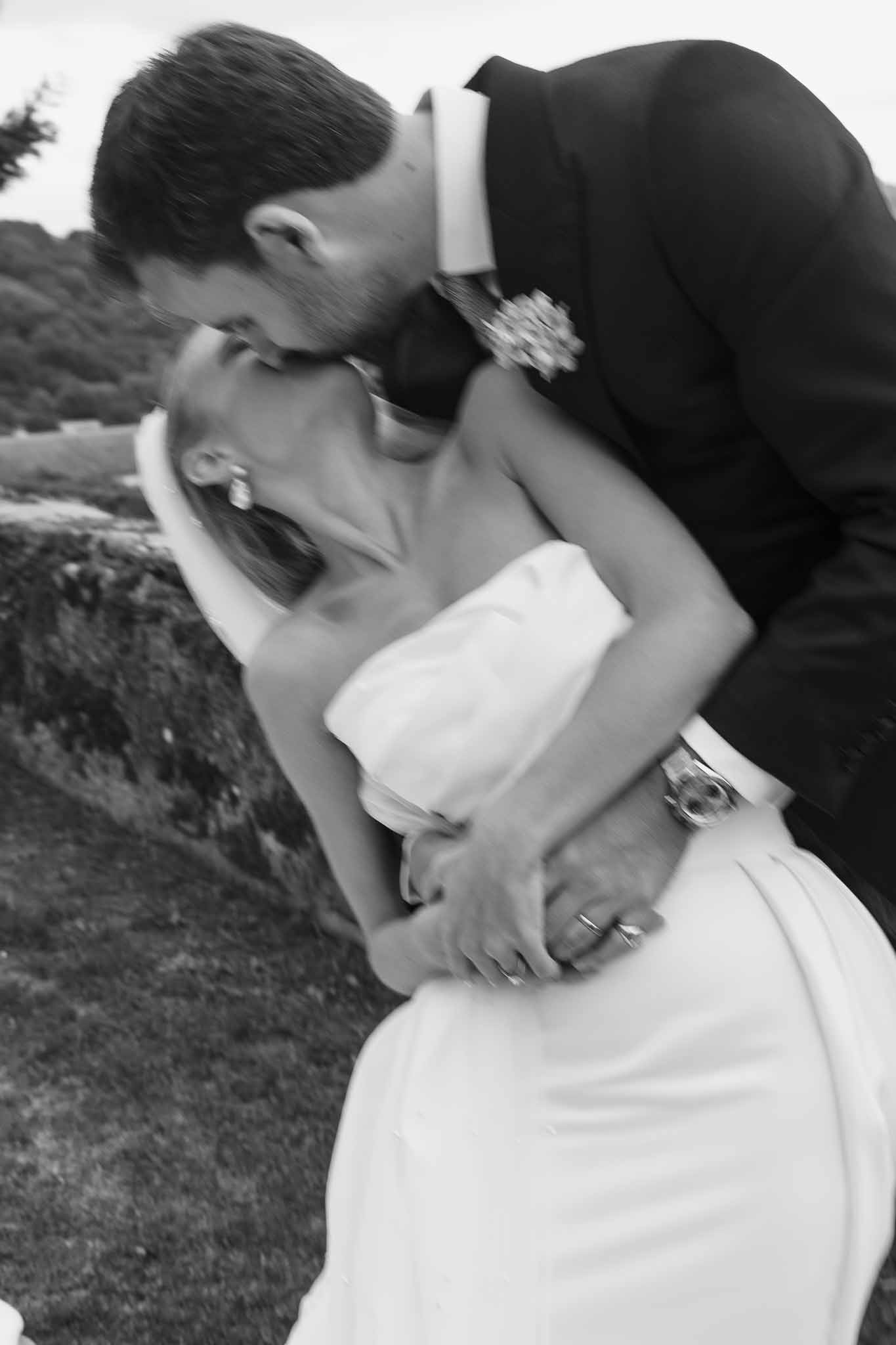 Black and white photo of bride and groom kissing