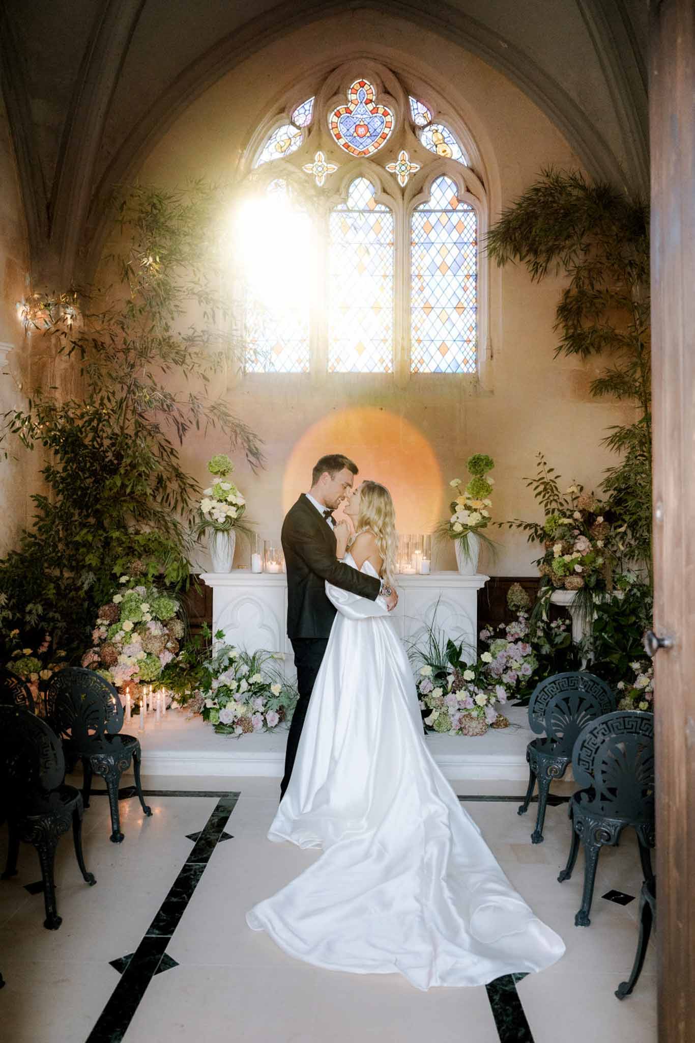 Black and white photo of wedding ceremony in a chapel with hydrangeas