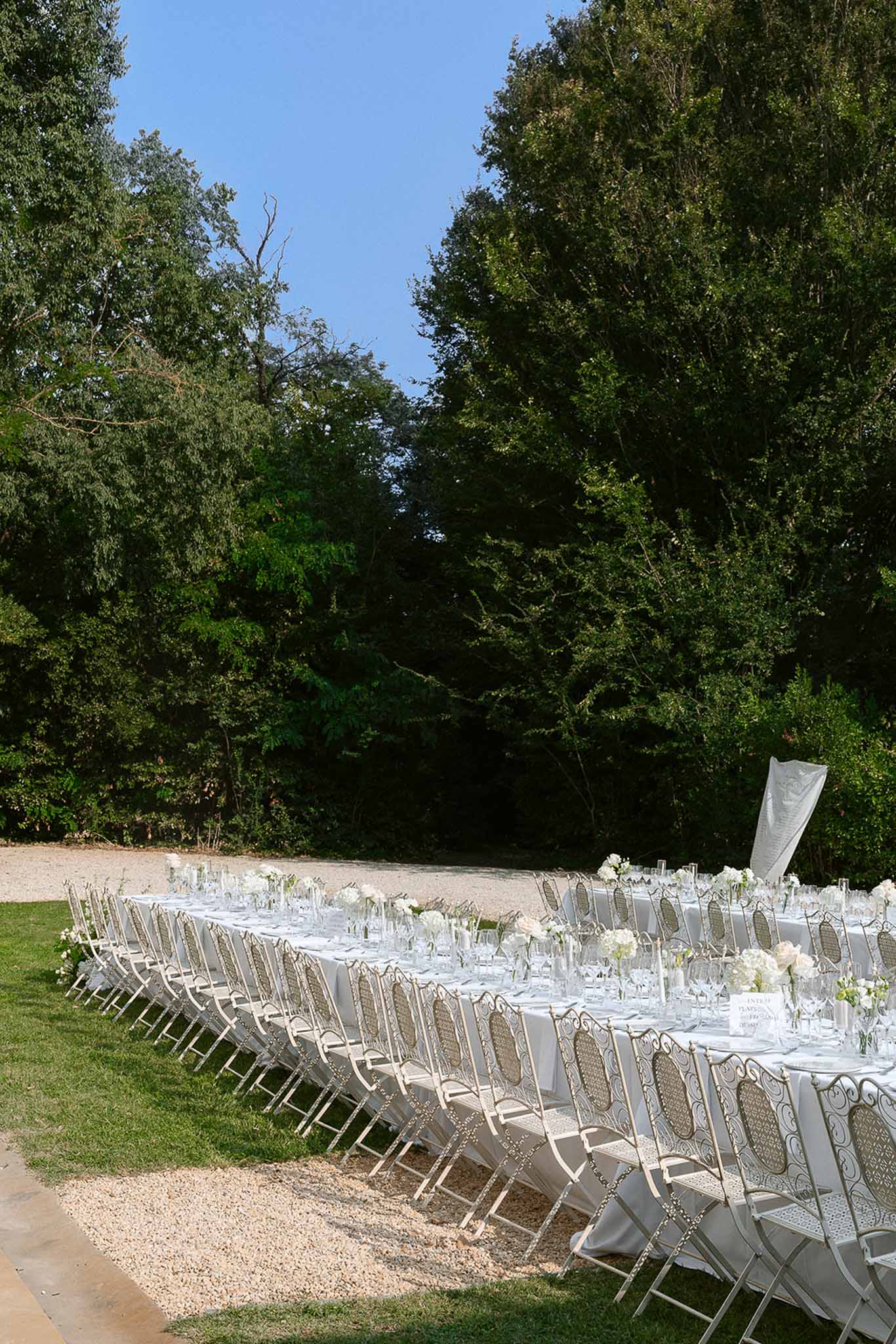 Wedding reception table setting in a garden with white roses