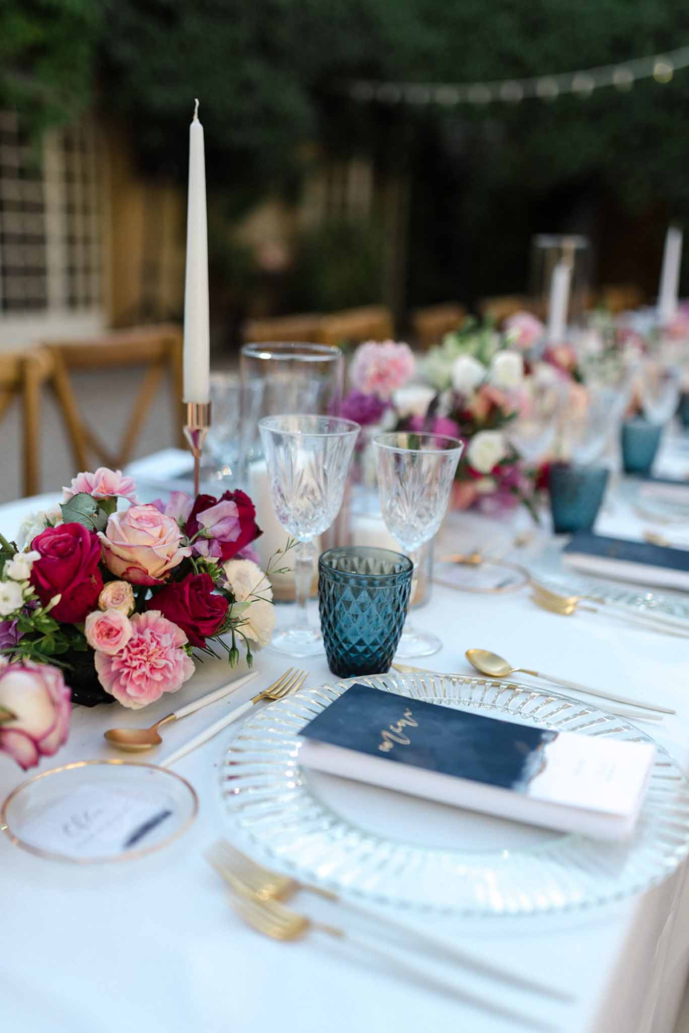 Wedding reception table setting in a garden with white roses
