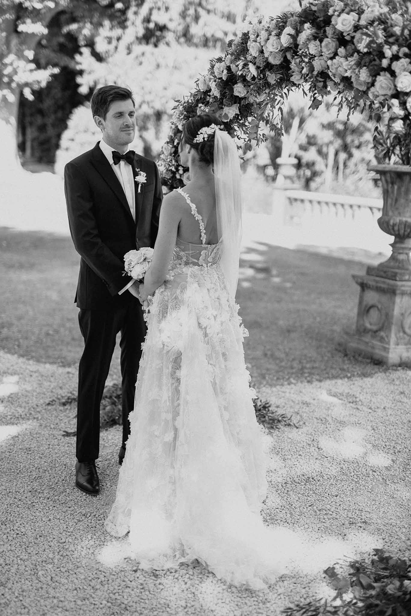 Black and white photo of wedding ceremony in a garden with white roses
