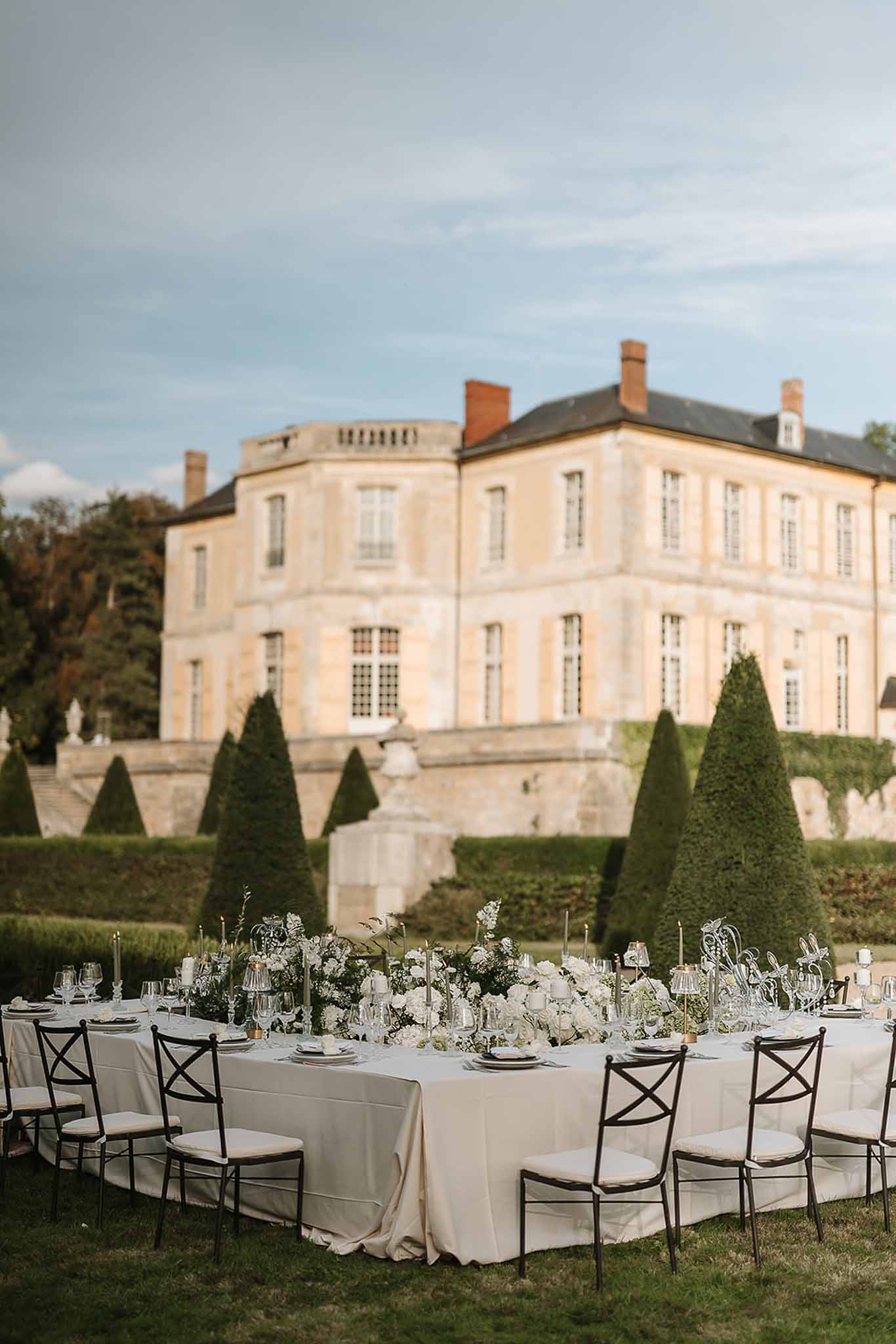 Wedding reception table setting in a garden with white roses