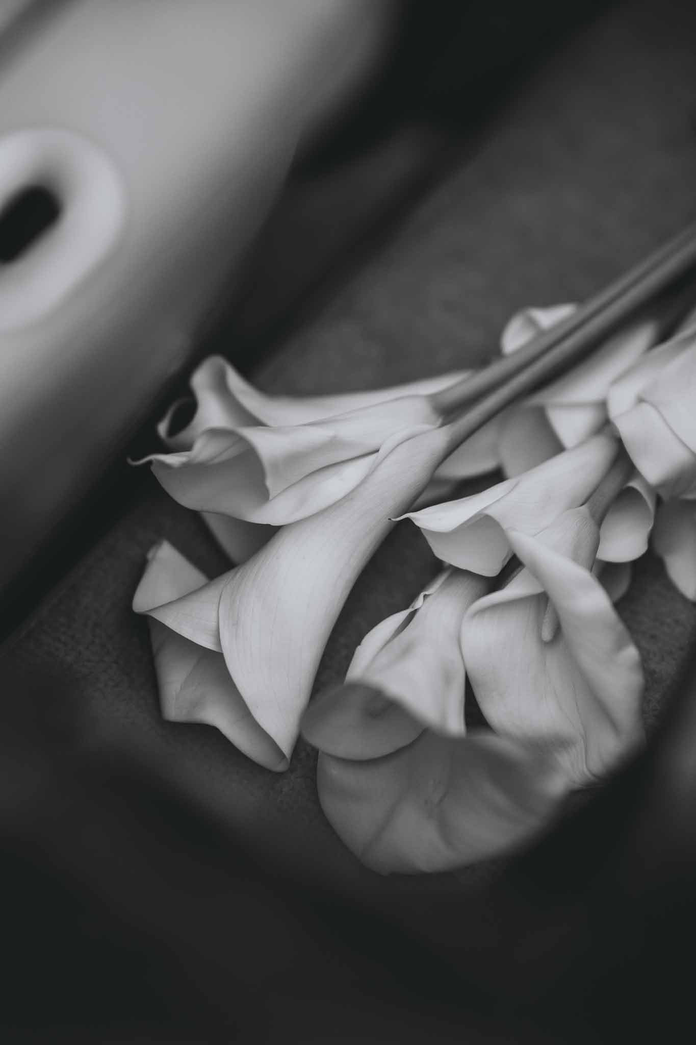 White bridal bouquet placed on the leather seat of the vintage car