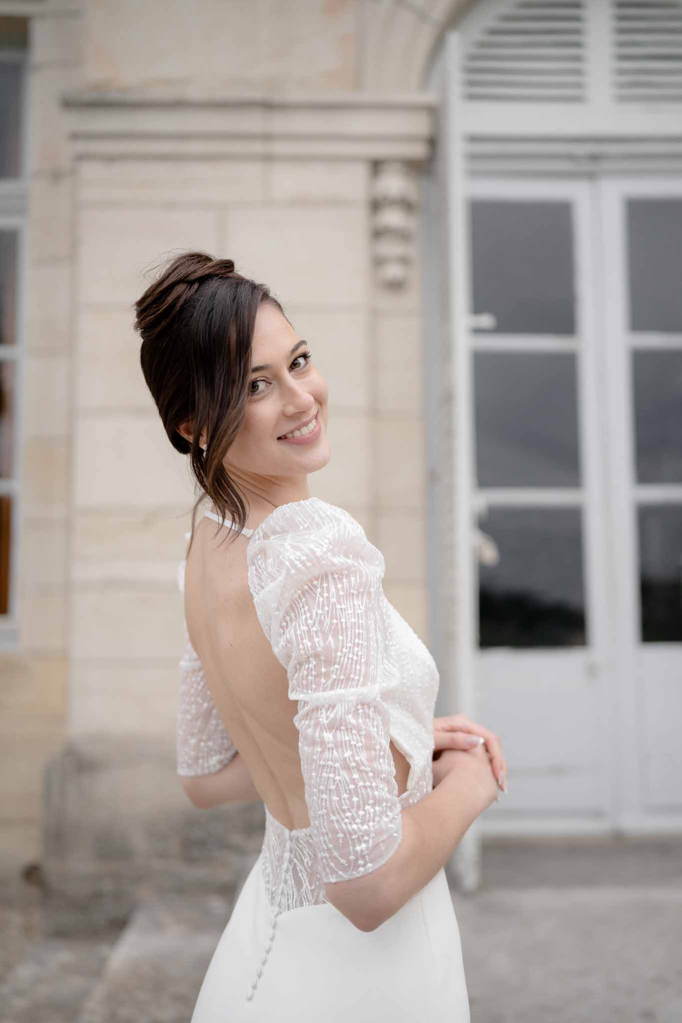 Bride walking away showing the open back and puff sleeves of her gown