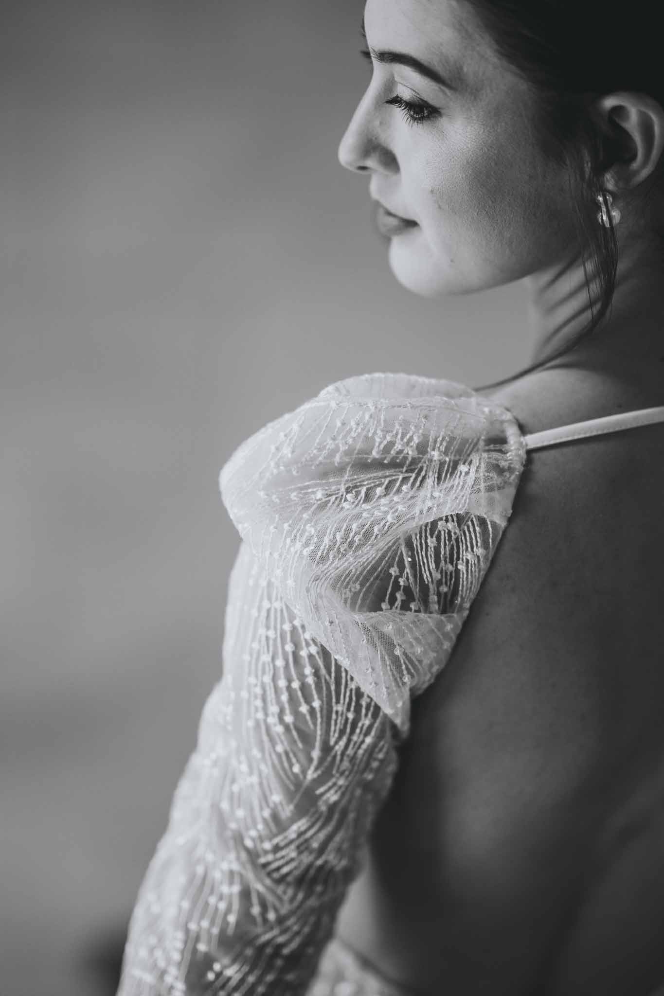 Detail of sparkly puff sleeves and open back on bride's wedding dress