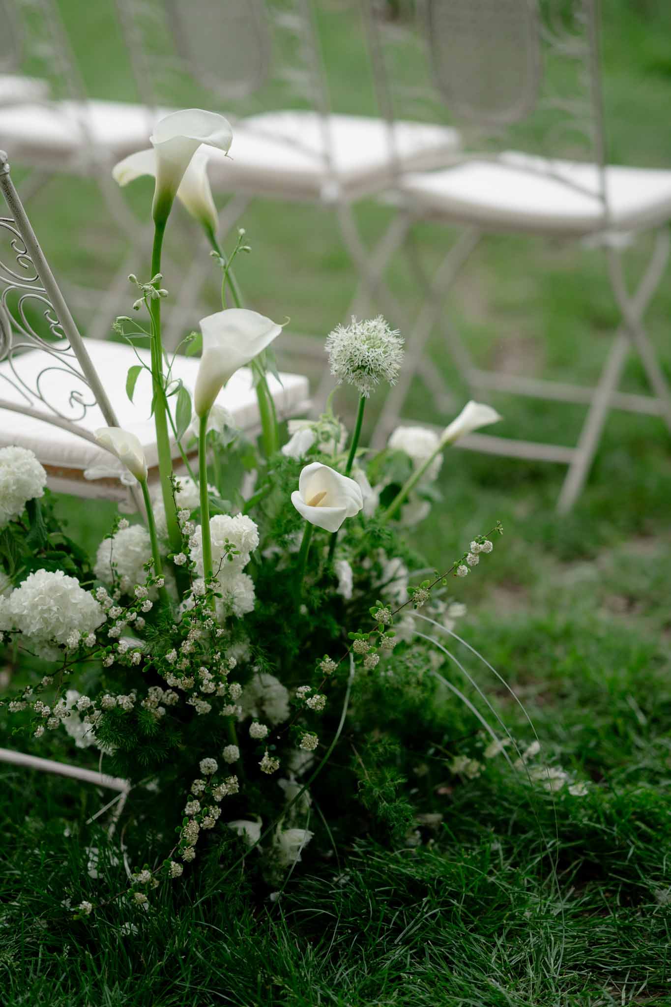 Ceremony aisle lined with white flowers and ornamental grass at Chateau d'Arcelot