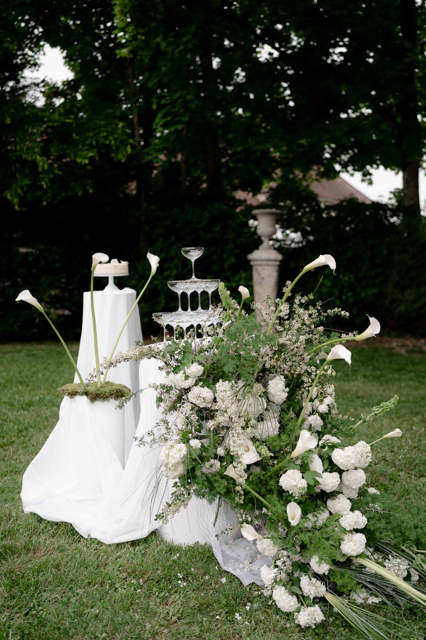 Champagne glass tower alongside cake tables at the reception